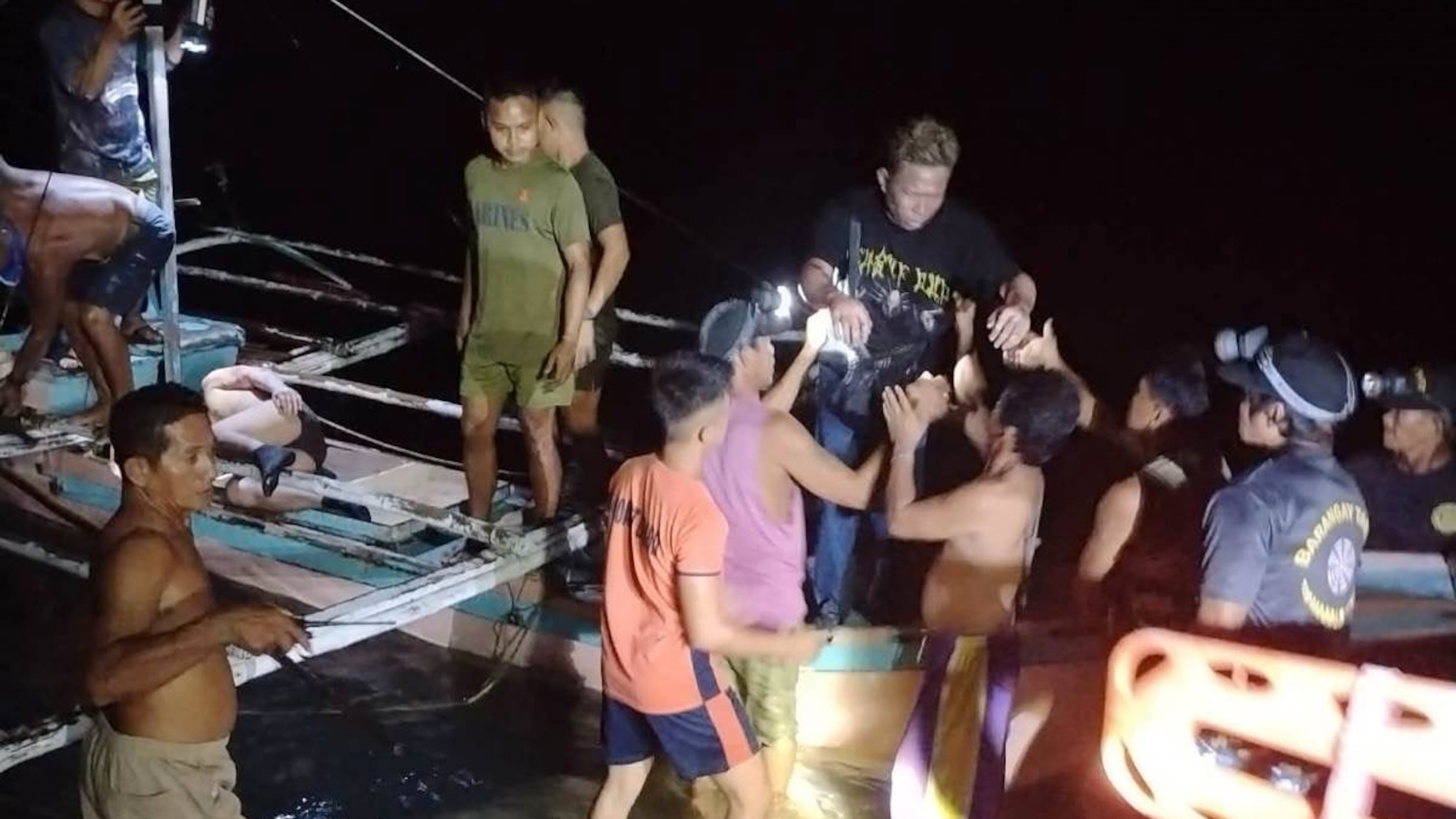 In this image provided by the Philippine Coast Guard, a survivor is assisted as he alights from a small boat after being rescued from a burning ferry off Palawan province, Philippines on Wednesday Sept. 9, 2026. (Philippine Coast Guard via AP)