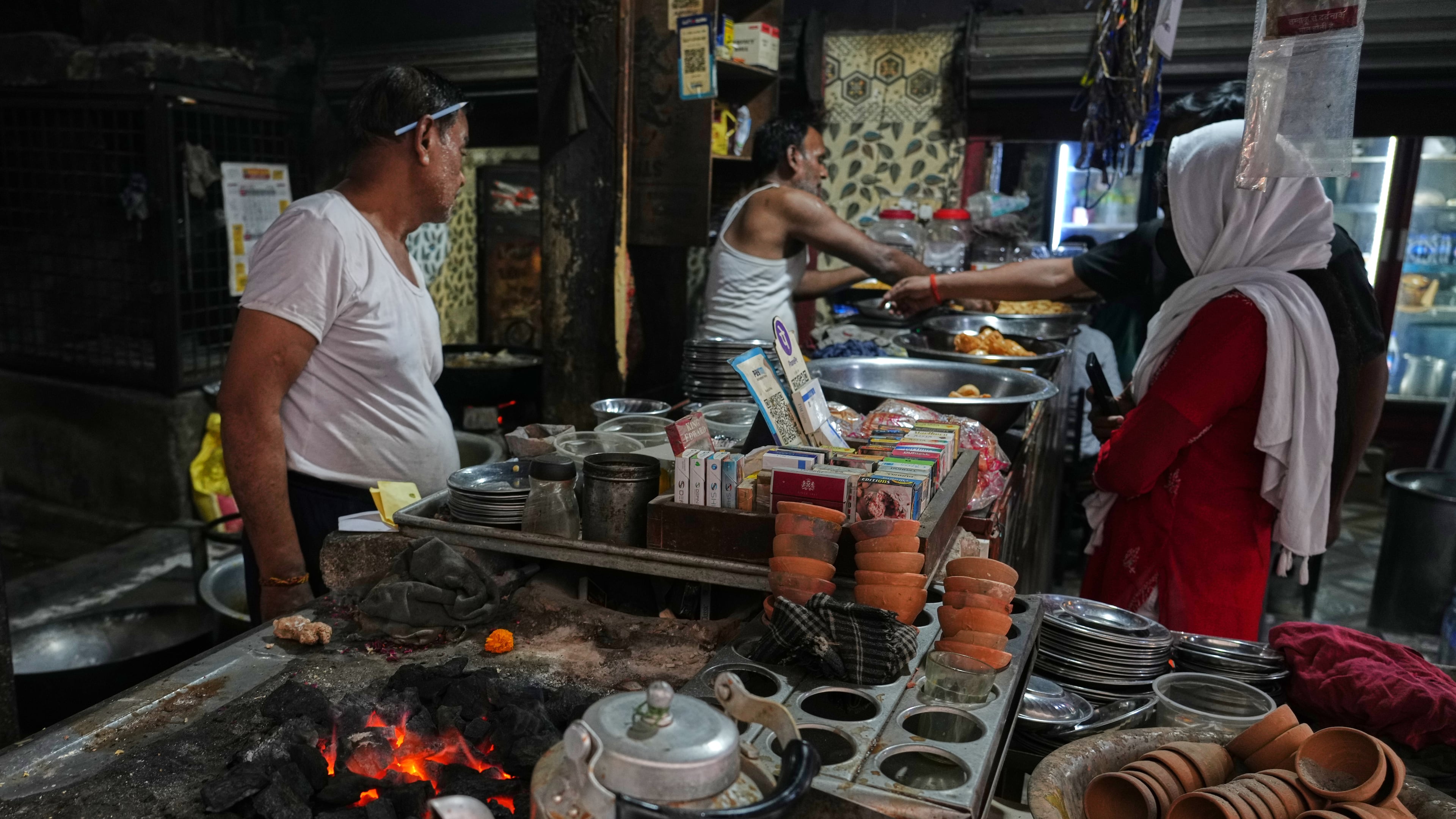 Workers cook over a coal fire at a small restaurant due to a shortage of commercial gas in Prayagraj, India, Friday, April 24, 2026. (AP Photo/Rajesh Kumar Singh)