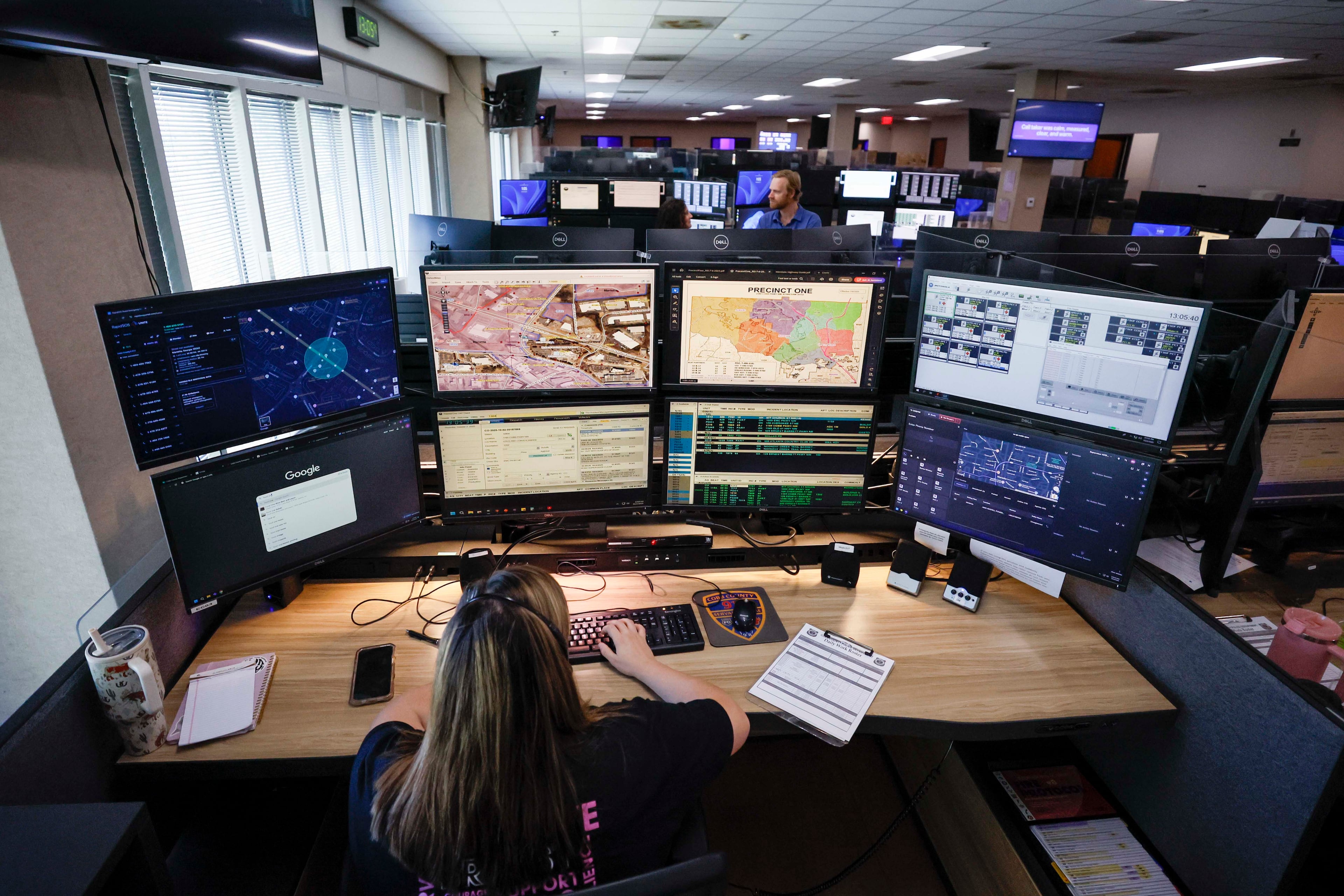 Emergency Communication Officer Julianna Shetterly is seen operating eight screens during her shift in October 2025. (Miguel Martinez/AJC)