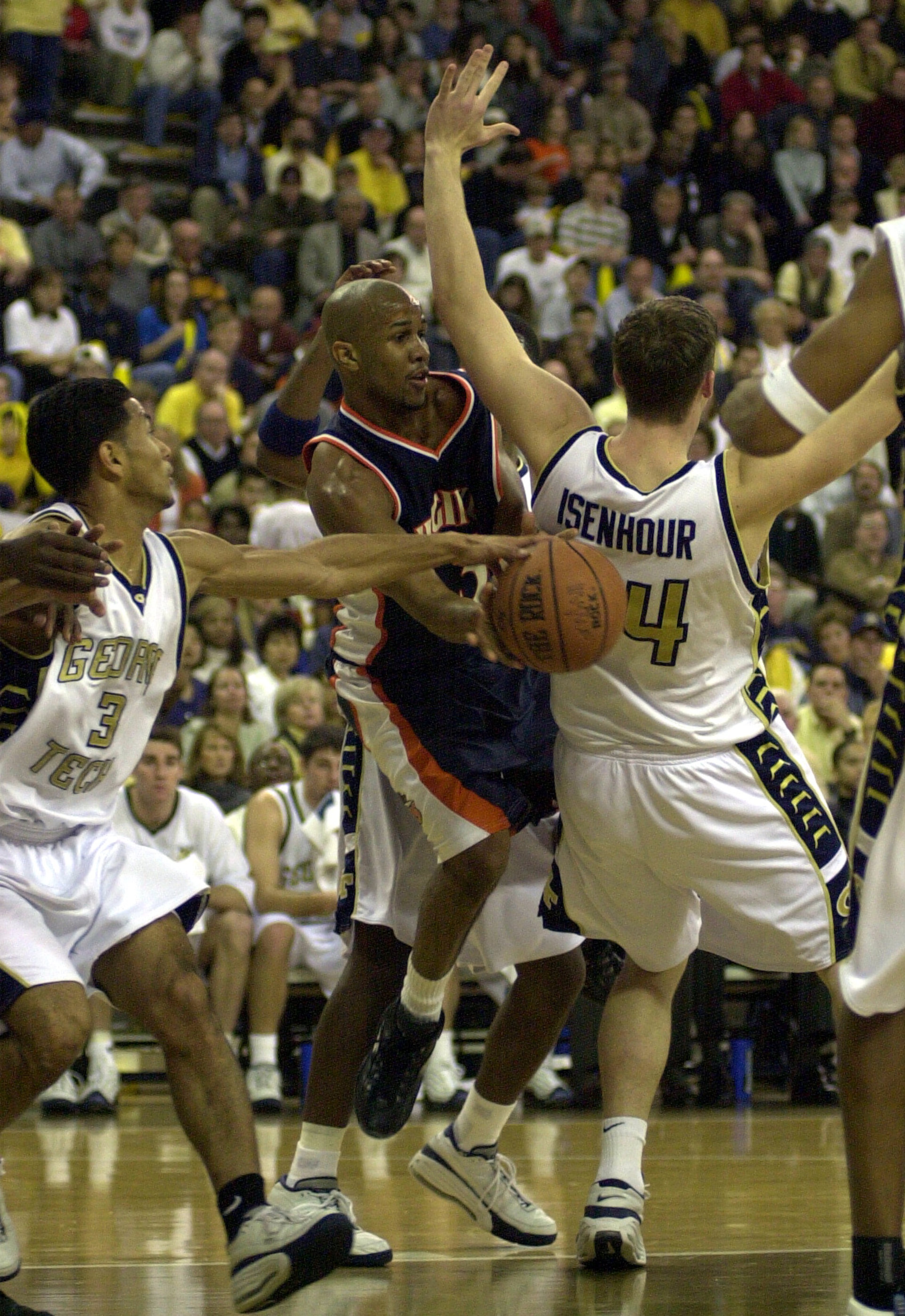 Feb. 11, 2001 -- Georgia Tech's Tony Akins, left, gives Virginia's Donald Hand, center, a hand on the ball as Tech's Michael Isenhour, right, leans into him. MARLENE KARAS / AJC FILE