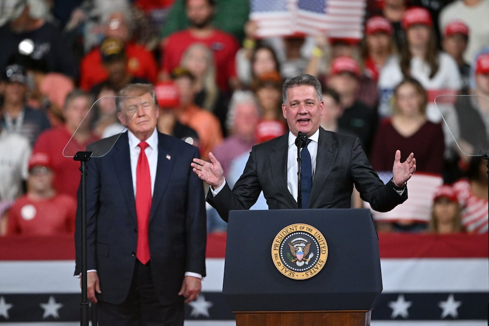 President Donald Trump, left, stands beside the CEO of Audi during a campaign rally at Guardian Centers in Perry on Saturday. (Hyosub Shin/AJC)