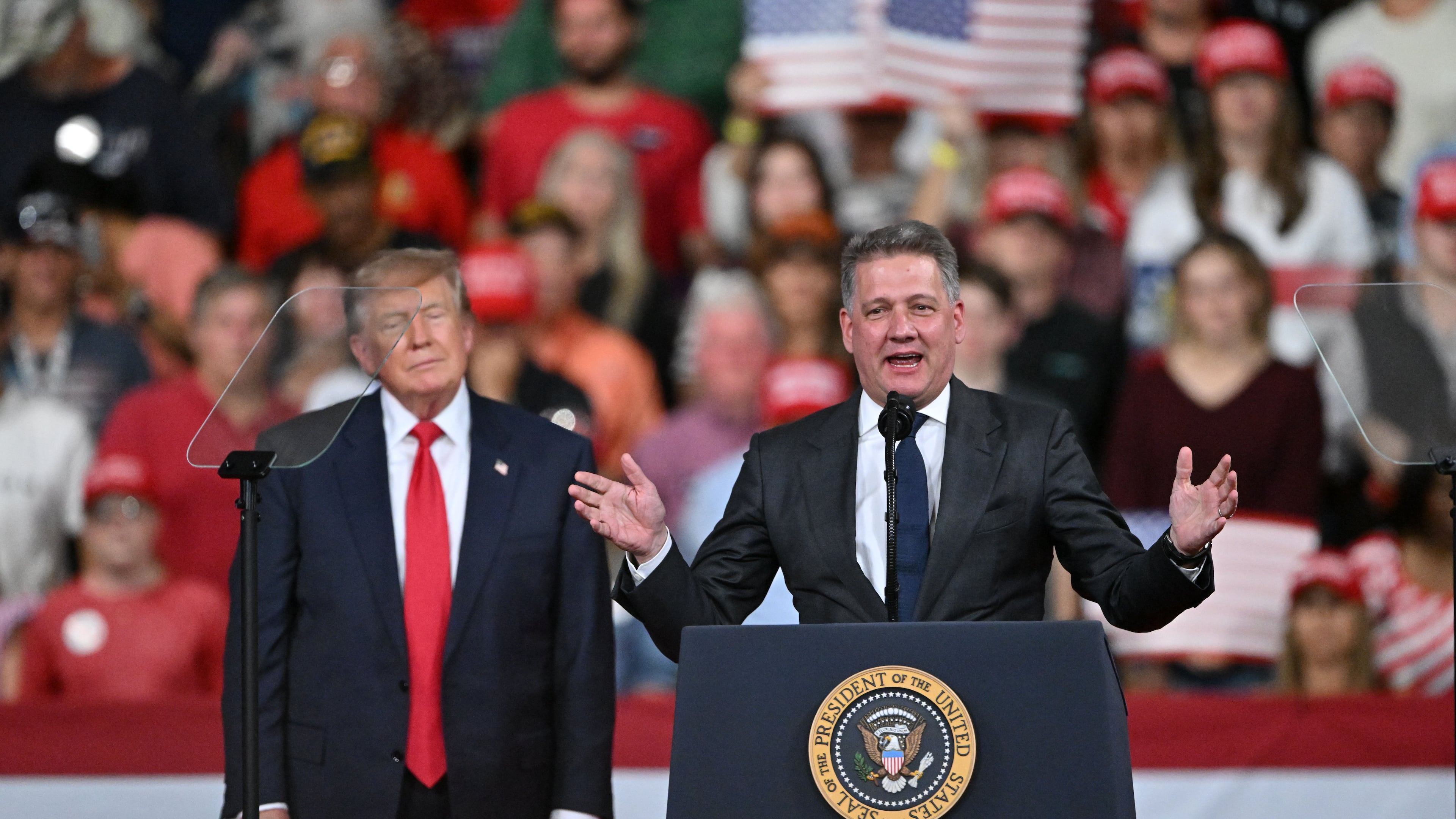 Gernot Döllner, CEO of Audi, speaks as President Donald Trump stands beside him during a midterm campaign rally at Guardian Centers in Perry on Saturday, Oct. 24, 2026. (Hyosub Shin/AJC)
