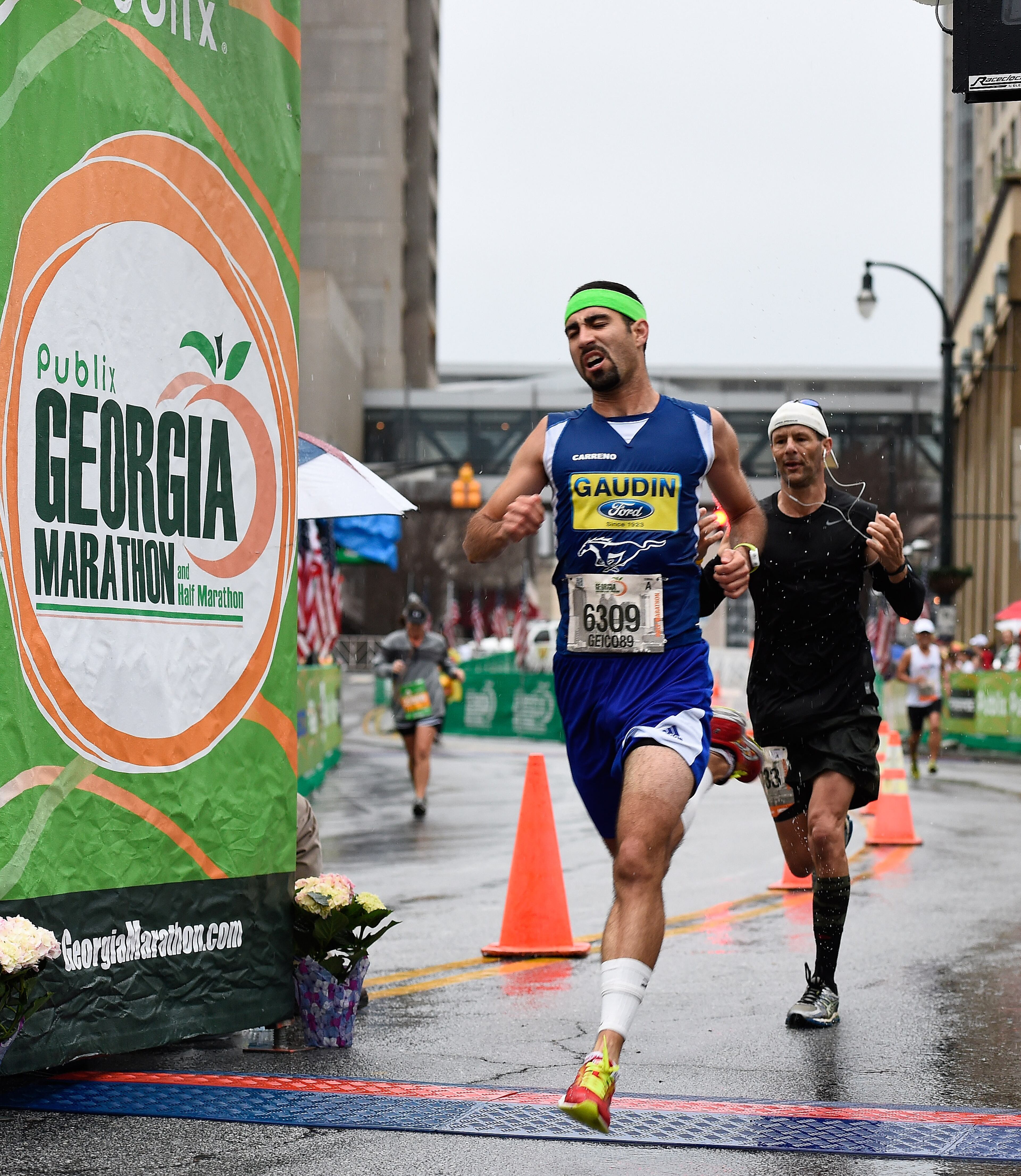 Alan Carreno, of Las Vegas, finishes the Publix Georgia Half Marathon during a steady rain on Sunday, March 22, 2015, in Atlanta. David Tulis / AJC Special