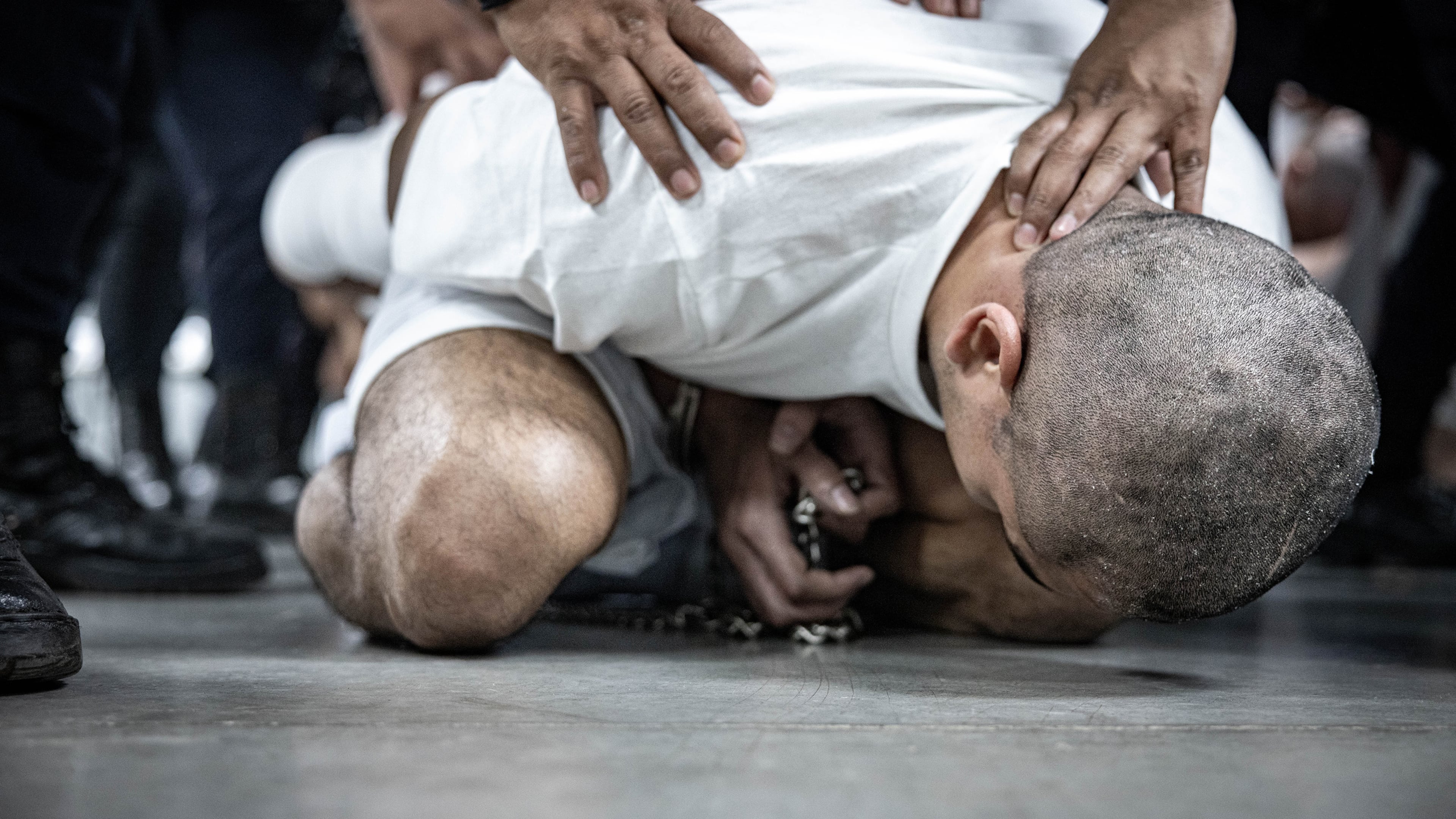 In this handout photo provided by the Salvadoran government, an inmate allegedly linked to criminal organizations is restrained by a guard at CECOT on March 16, 2025, in Tecoluca, El Salvador. (Salvadoran Government/Getty Images/TNS)