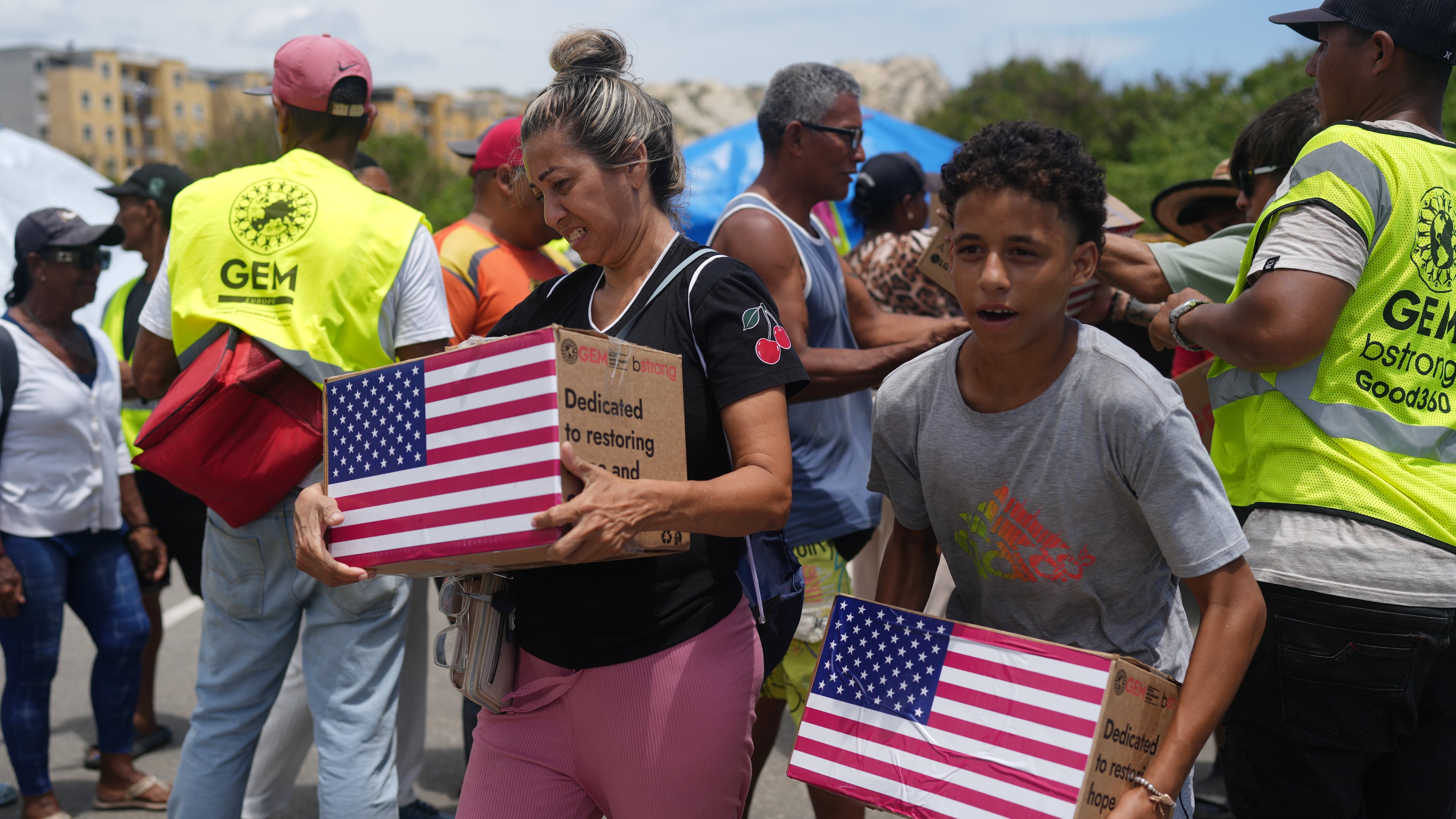 People affected by the earthquakes carry U.S. humanitarian aid after receiving it in La Guaira, Venezuela, Wednesday, July 8, 2026. (AP Photo/Ariana Cubillos)