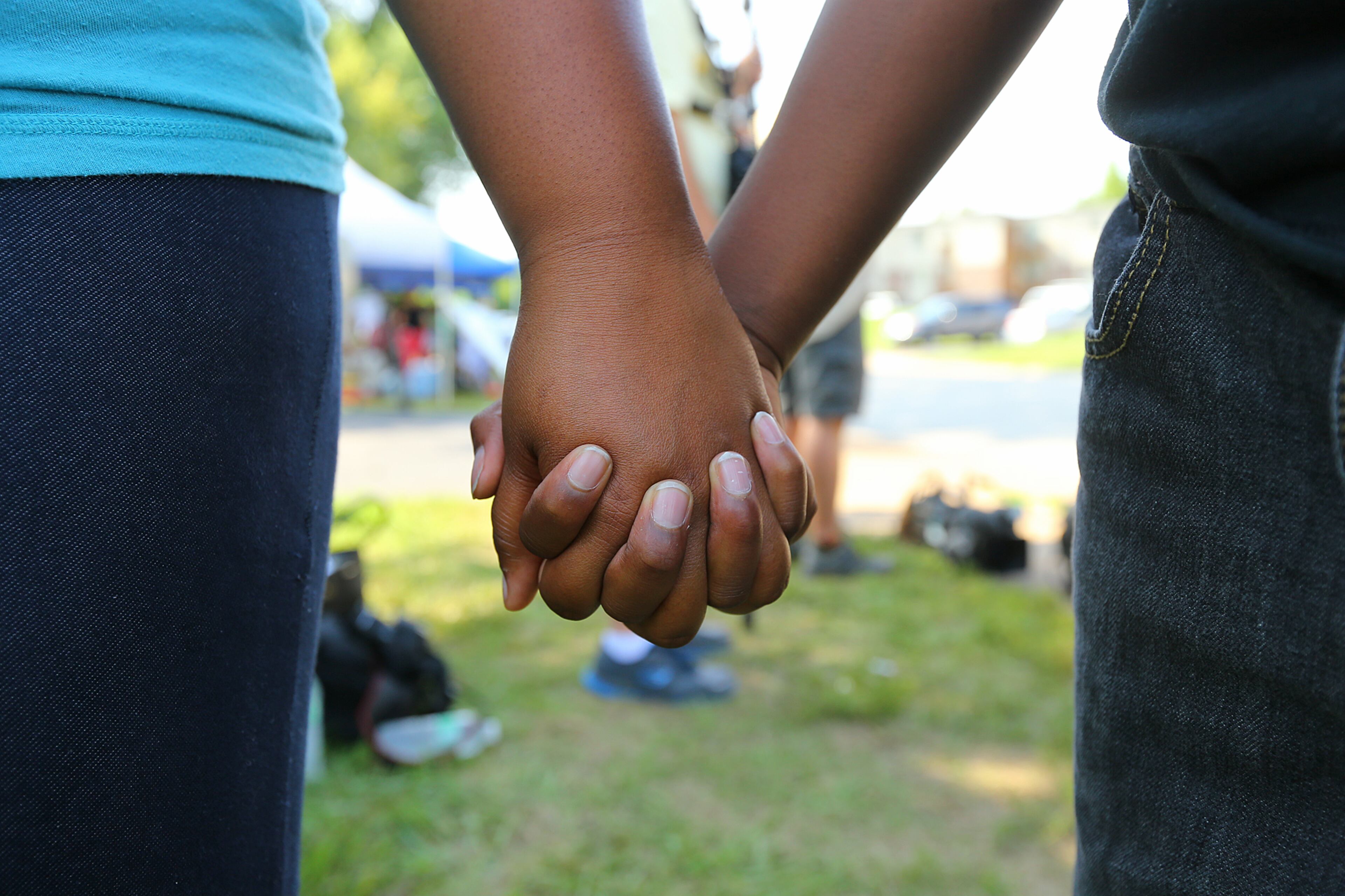 Shaunte Watson holds hands with her 11-year-old son Kahn Key in the Canfield Apartments where Michael Brown was killed on Saturday, Aug. 9, 2014, in Ferguson. CURTIS COMPTON / CCOMPTON@AJC.COM