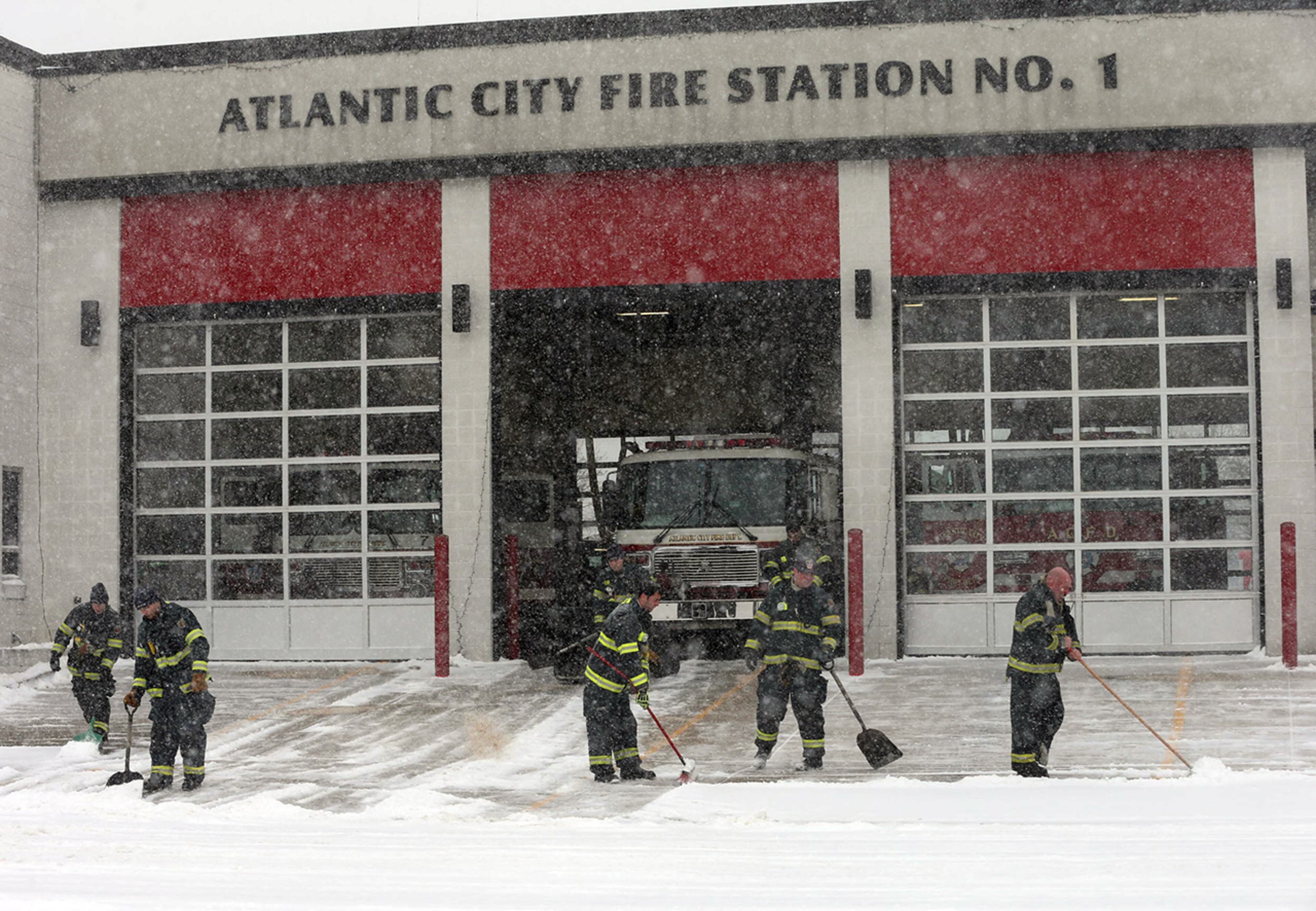 Firefighters clear snow from the front of Fire Station 1 in Atlantic City, N.J, Monday March 3, 2014. Winter kept its icy hold on much of the country Monday, with snow falling and temperatures dropping as schools and offices closed and people from the South and Mid-Atlantic to Northeast reluctantly waited out another storm indoors. (AP Photo/The Press of Atlantic City, Michael Ein)