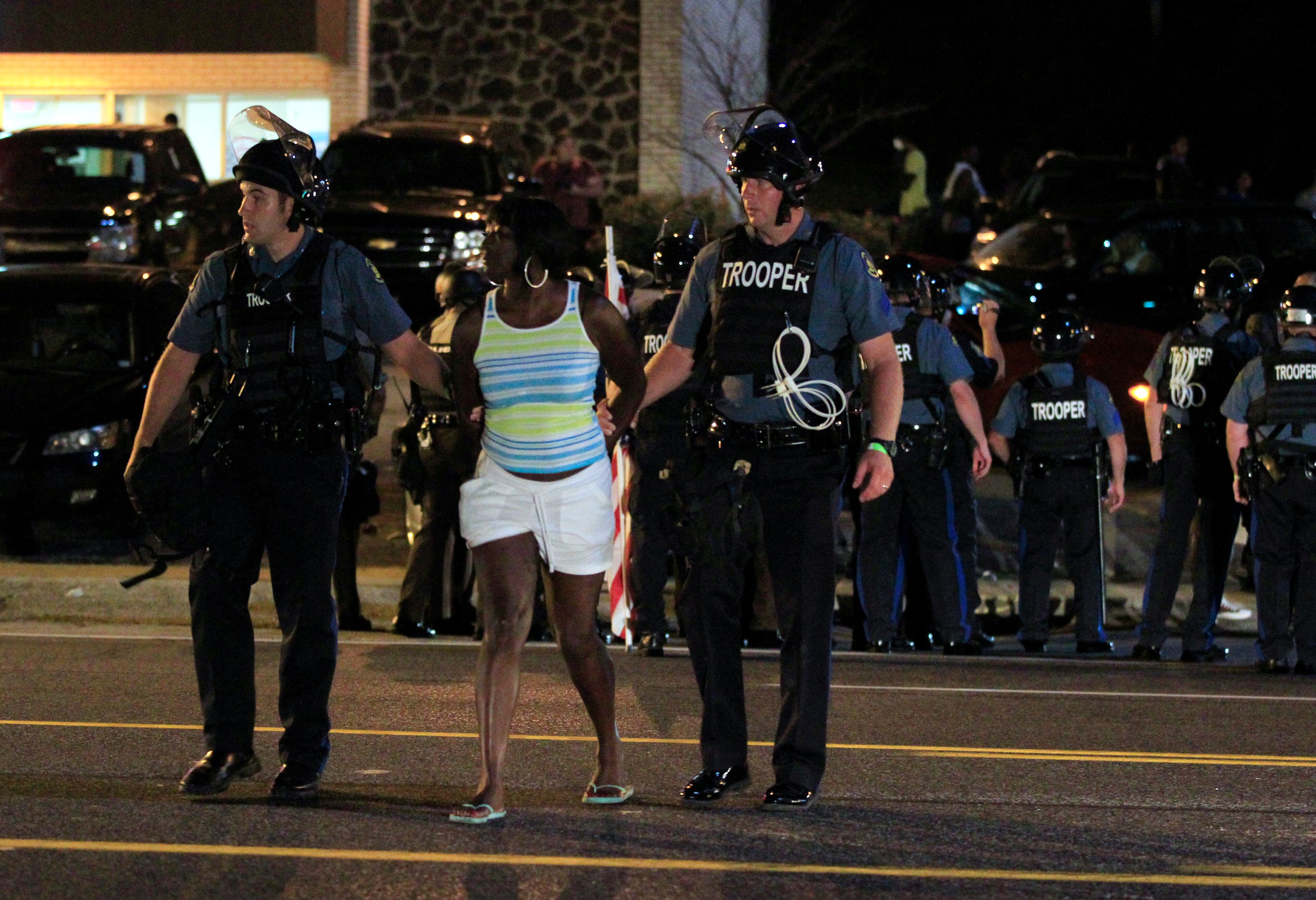 Officers arrest a protester Aug. 10, 2015, in Ferguson, Mo. Ferguson was a community on edge again Monday, a day after a protest marking the anniversary of Michael Brown's death was punctuated with gunshots.
