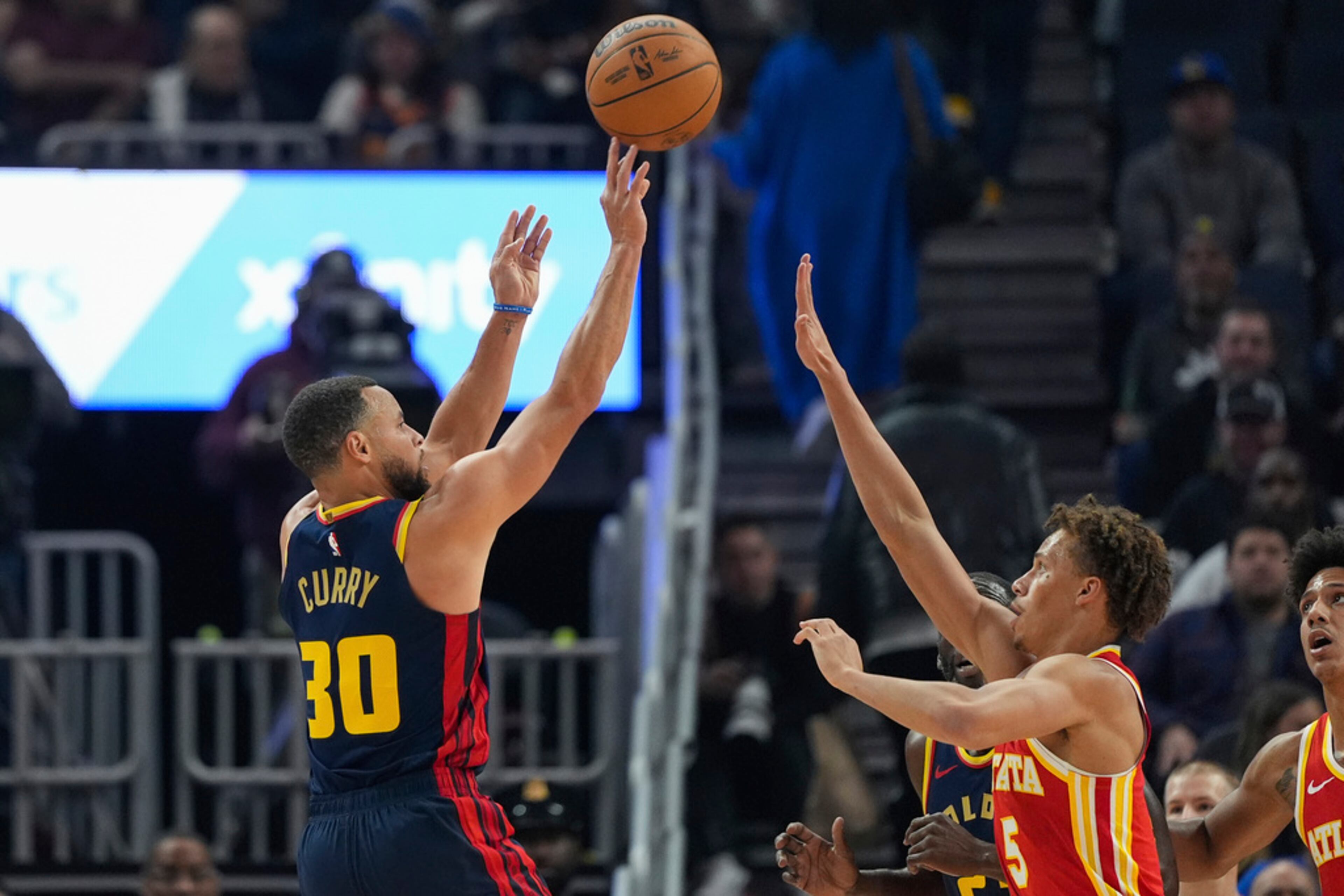 Golden State Warriors guard Stephen Curry, left, shoots over Atlanta Hawks guard Dyson Daniels (5) during the first half of an NBA basketball game Wednesday, Nov. 20, 2024, in San Francisco. (AP Photo/Godofredo A. Vásquez)