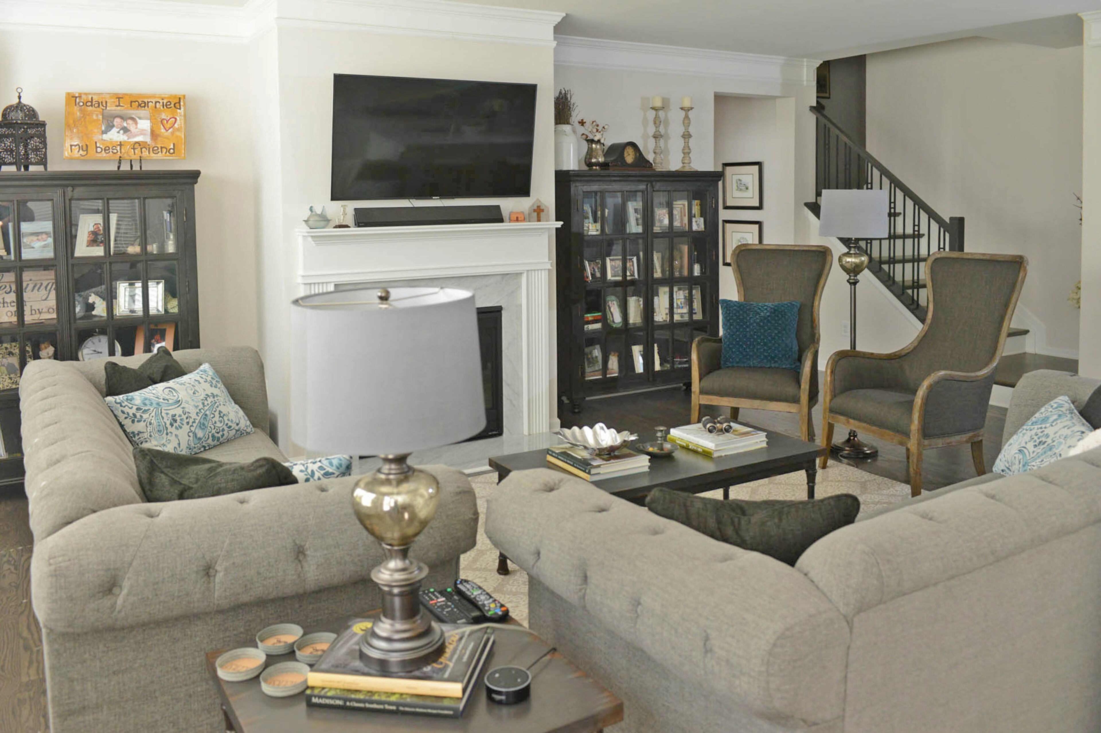 Glass door cabinets from Crate & Barrel, displaying family photos, books and travel souvenirs, frame the fireplace in the living room, creating a stylish space to show personal touches. Two wingback chairs from Outrageous Interiors give the room balance, while the lamps are from Pier 1 Imports.