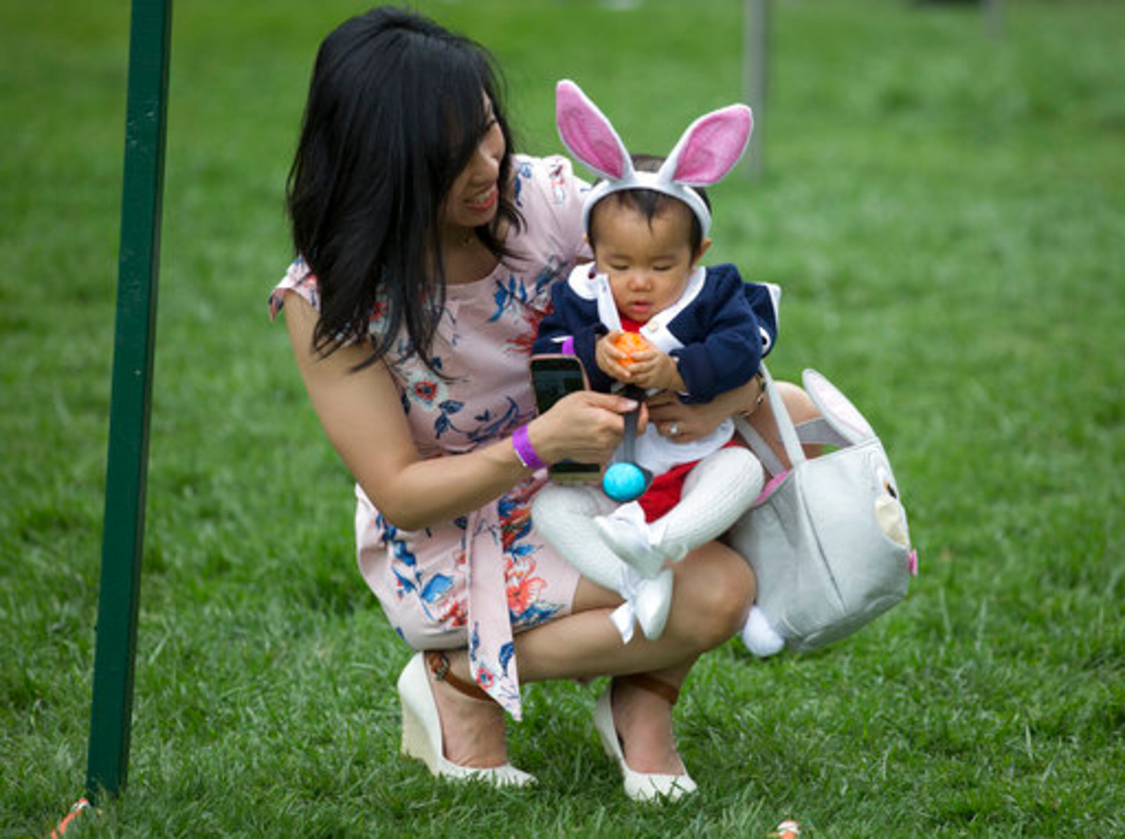 Eleven-month-old Victoria Cheng and her mother Guliana Cheng, both from San Francisco, prepare to participate in the White House Easter Egg Roll on the South Lawn of the White House in Washington, Monday, April,17, 2017. President Donald Trump and first lady Melania Trump are set to host the official annual Easter egg roll at the White House.(AP Photo/Carolyn Kaster)