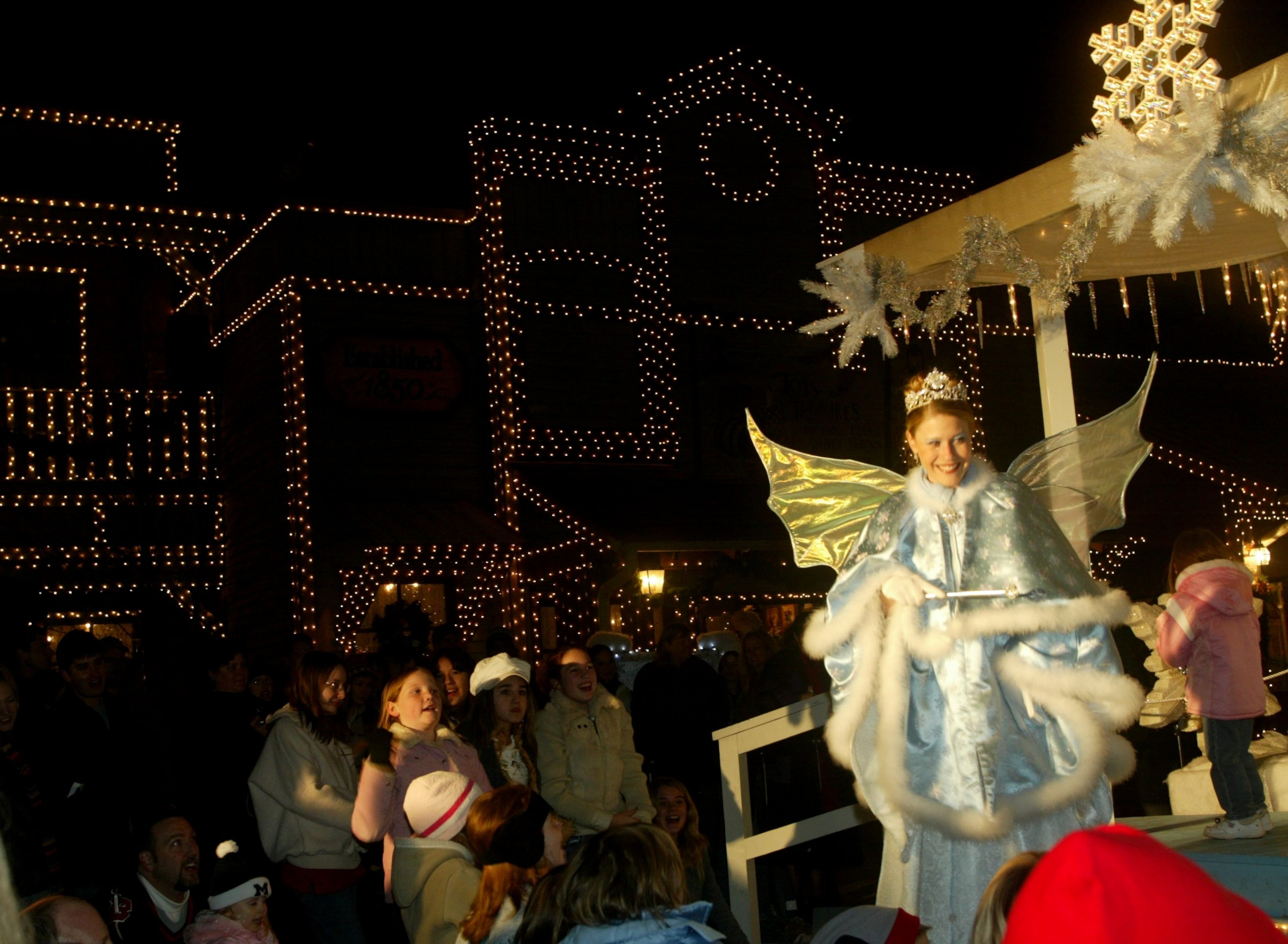 Stone Mountain Park's snow angel, Angelina, right, also known as Lenae Rose, 26, of Covington, gets help from children ringing bells and motioning for snow when a flurry of white flakes covers the group in 2004. (FILE)