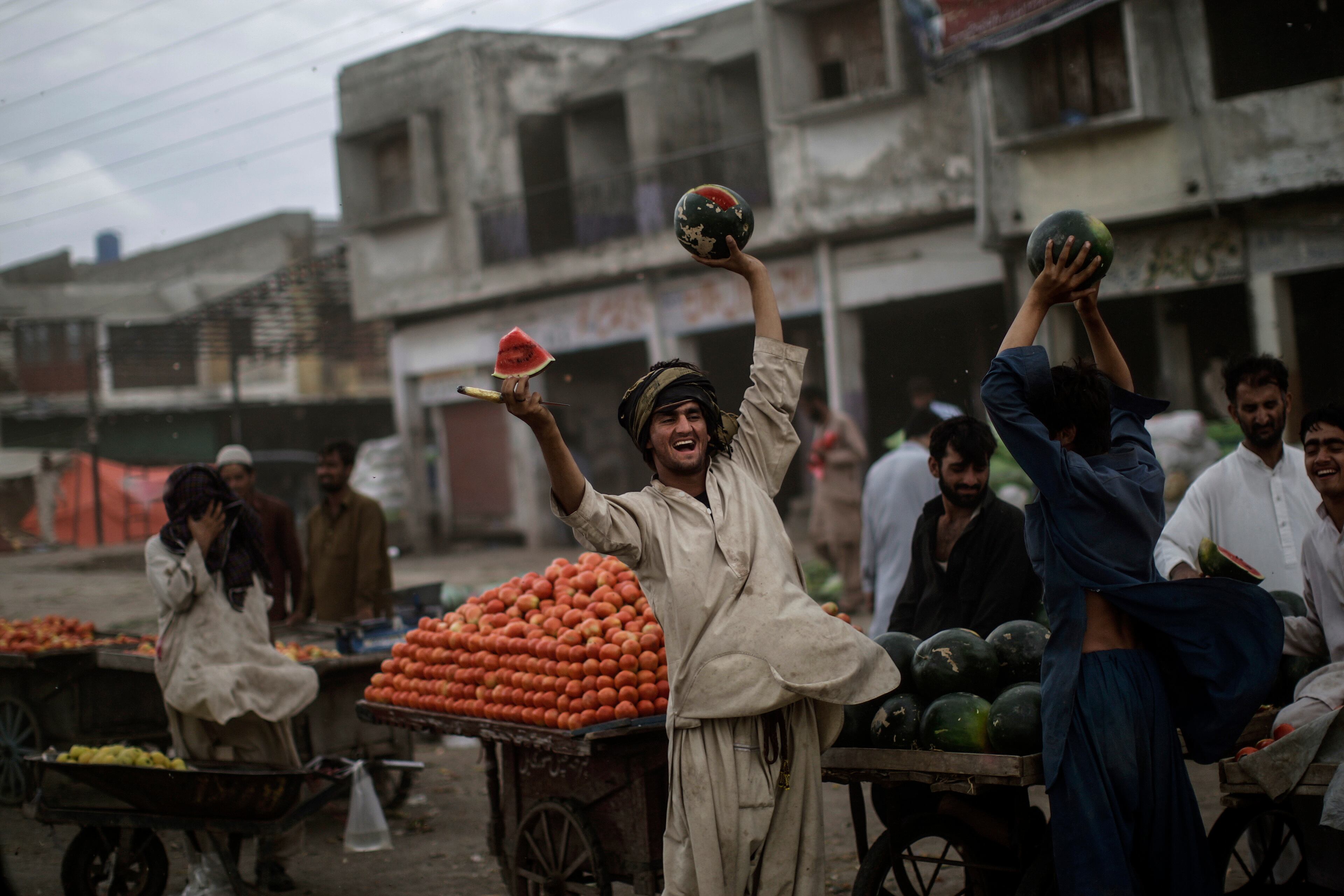 Pakistani watermelon seller, Habibullah Mohammed, 15, attracts customers by offering a free slice, at a wholesale fruits and vegetables market on the outskirts of Islamabad, Pakistan, Monday, June 17, 2013. Habibullah sells a Kilo of watermelon for 10 Rupees ($0.101 cents). (AP Photo/Muhammed Muheisen)