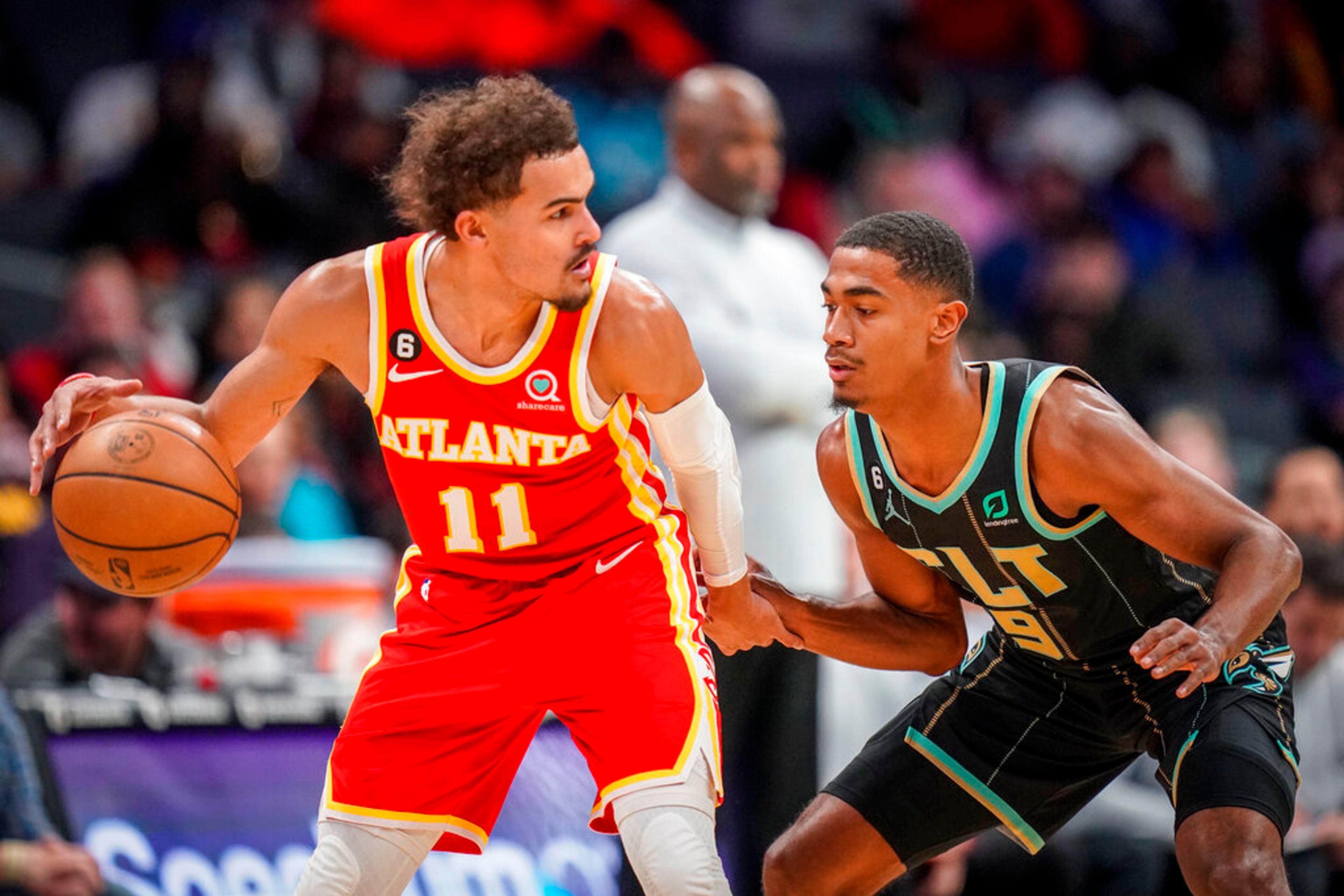 Atlanta Hawks guard Trae Young (11) is guarded by Charlotte Hornets guard Theo Maledon (9) during the first half of an NBA basketball game Friday, Dec. 16, 2022, in Charlotte, N.C. (AP Photo/Rusty Jones)