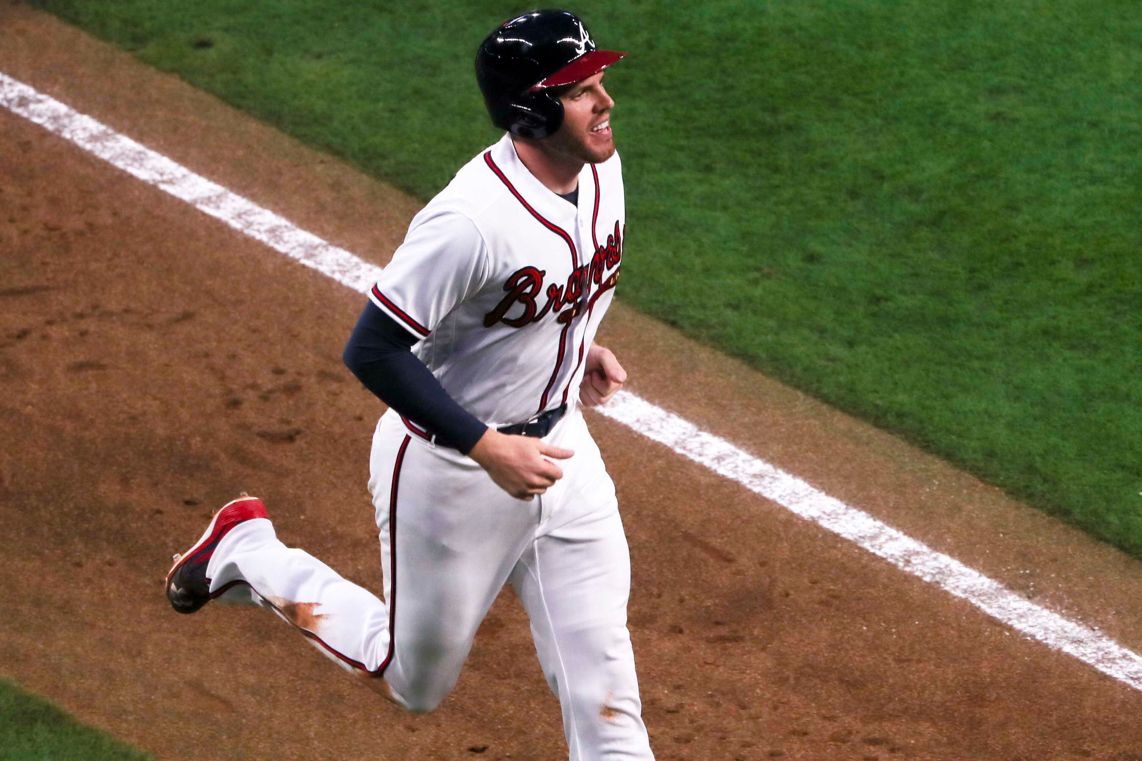 03/29/2018 -- Atlanta, GA - Nick Markakis (22) smiles as he runs inept home plate after hitting a home run in the ninth inning against the Philadelphia Phillies for the season opener game at SunTrust Park, Thursday, March 29, 2018. The Braves beat the Phillies, 8-5. ALYSSA POINTER/ALYSSA.POINTER@AJC.COM