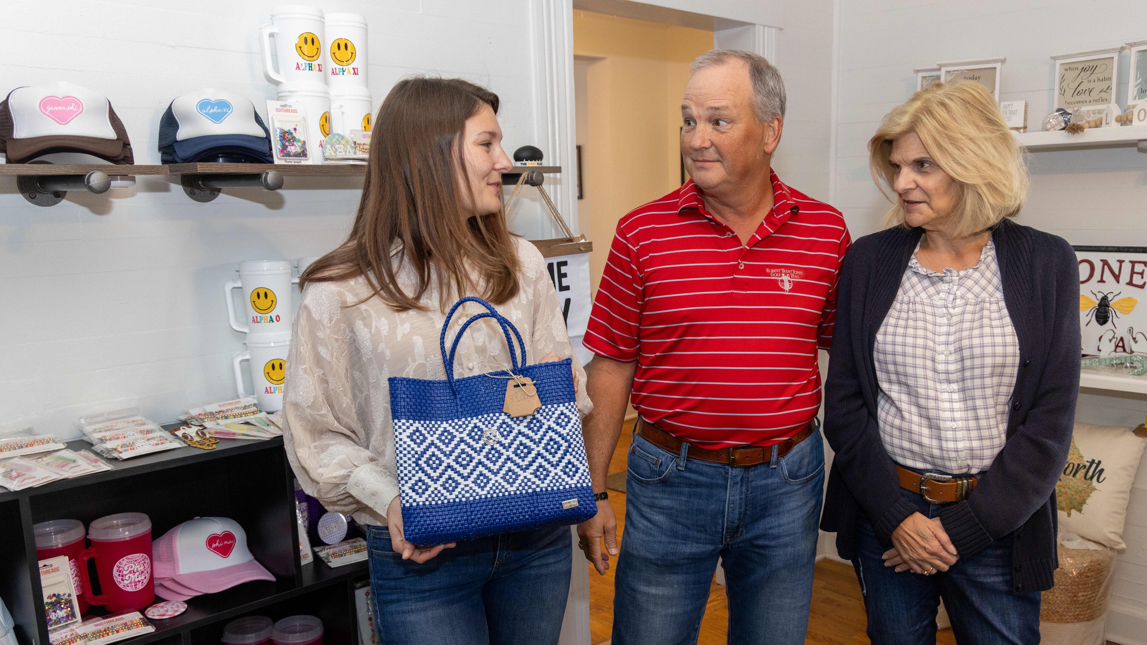 Haily Clark (from left, and her parents Craig & Kathy talk about items for sale in ÒEmilyÕs CornerÓ inside The Brain Station in Kennesaw. Emily Clark was killed in a car accident 9 years ago. This October, her family honored her by opening The Brain Station, a coffee shop that offers tutoring and has a boutique. PHIL SKINNER FOR THE ATLANTA JOURNAL-CONSTITUTION