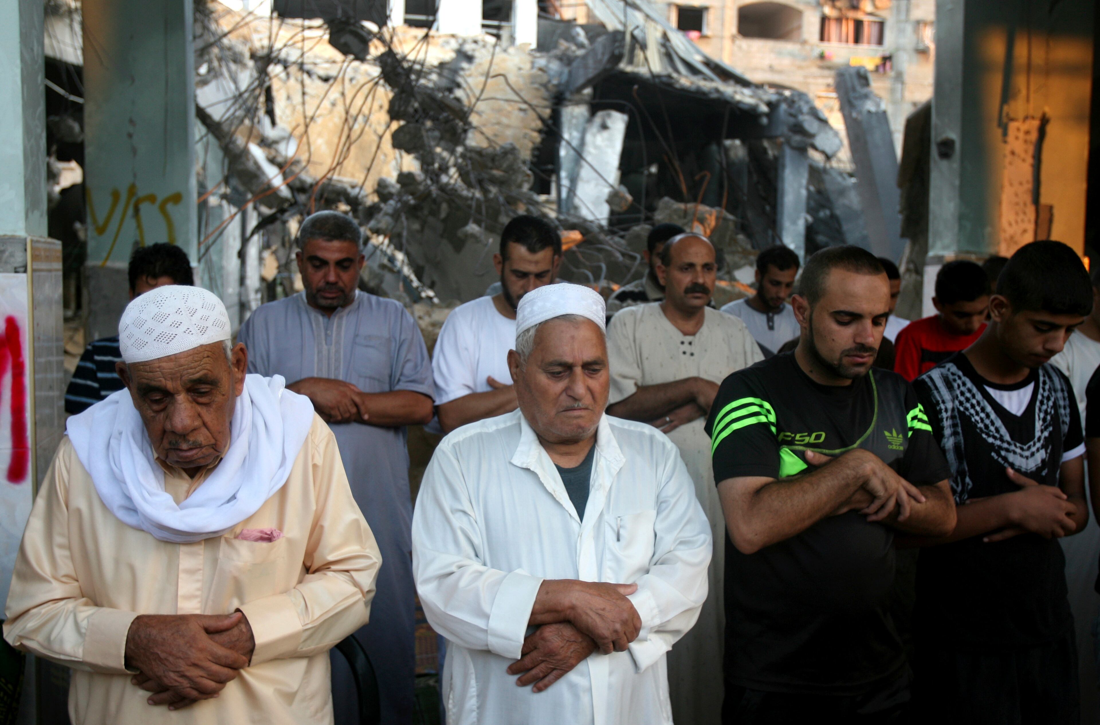 Palestinians pray early morning prayer during the first day of Eid al-Fitr, which marks the end of the Muslim fasting month of Ramadan, inside the destroyed Al Farouk mosque which was destroyed by an overnight Israeli strike on Tuesday, in Rafah, in the southern Gaza Strip, Monday, July 28, 2014. As Muslims began celebrating the Eid al-Fitr holiday on Monday that marks the end of the fasting month of Ramadan, there was mostly fear and mourning instead of holiday cheer in the Gaza Strip.