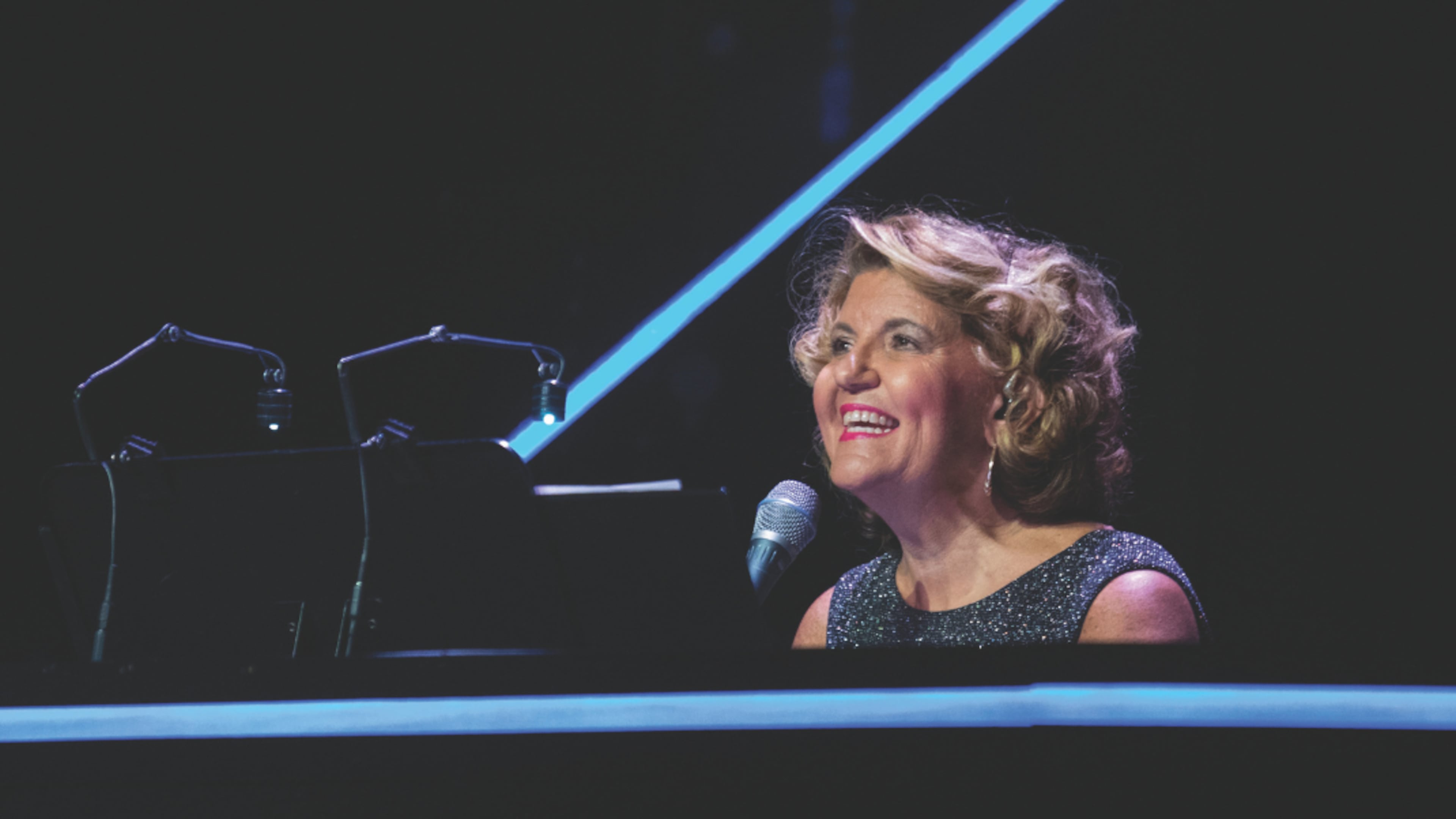 Ann-Carol Pence has served as “Christmas Canteen’s” music director, arranger and conductor for 30 years. Mixing music, comedy skits and dance numbers, the Aurora Theatre holiday show continues through Dec. 21. (Photo by Casey Gardner Ford)