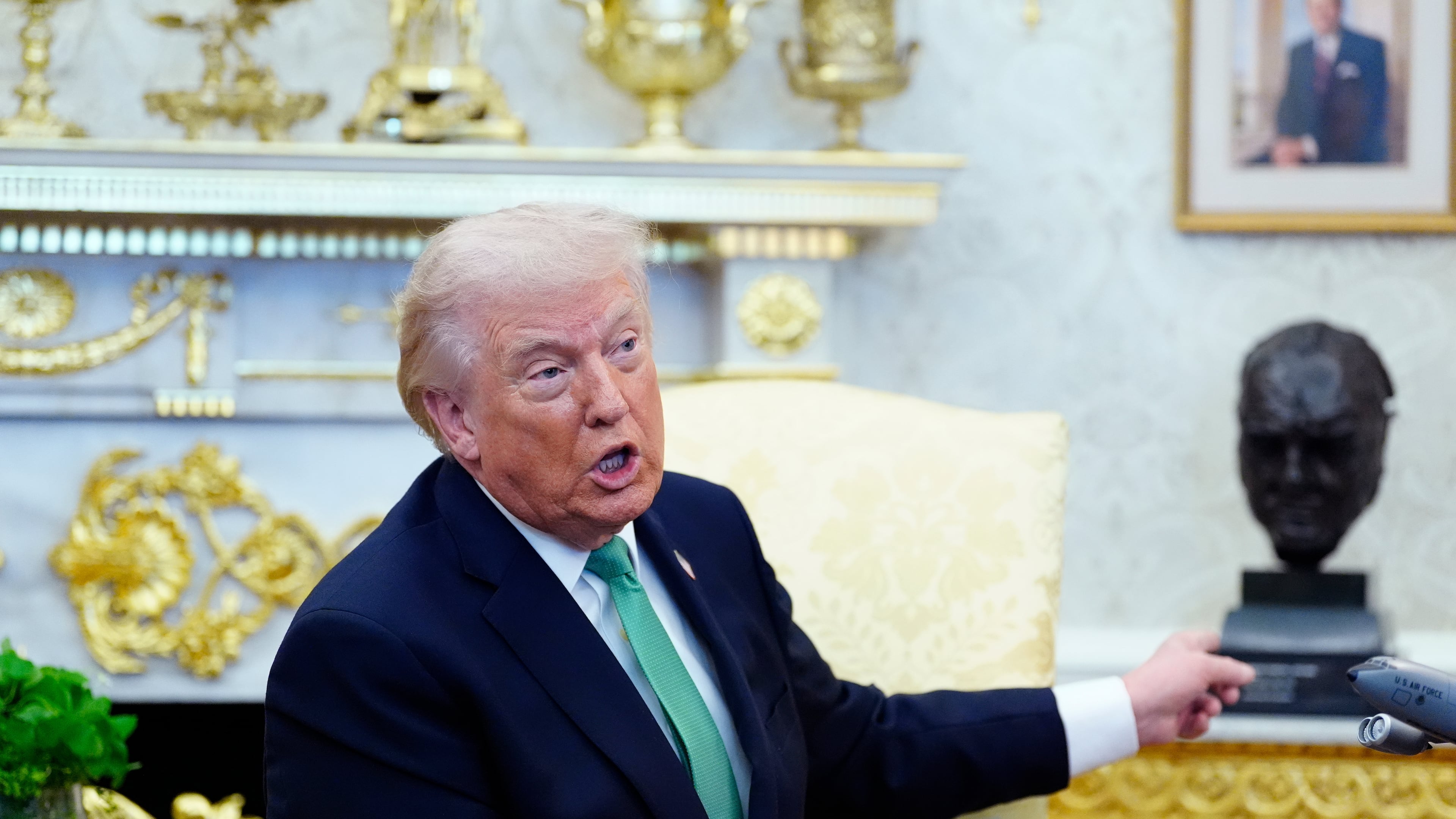 President Donald Trump points to a bust of Winston Churchill as he speaks during a meeting with Irish Prime Minister Micheál Martin in the Oval Office of the White House, on St. Patrick's Day, Tuesday, March 17, 2026, in Washington. (AP Photo/Alex Brandon)