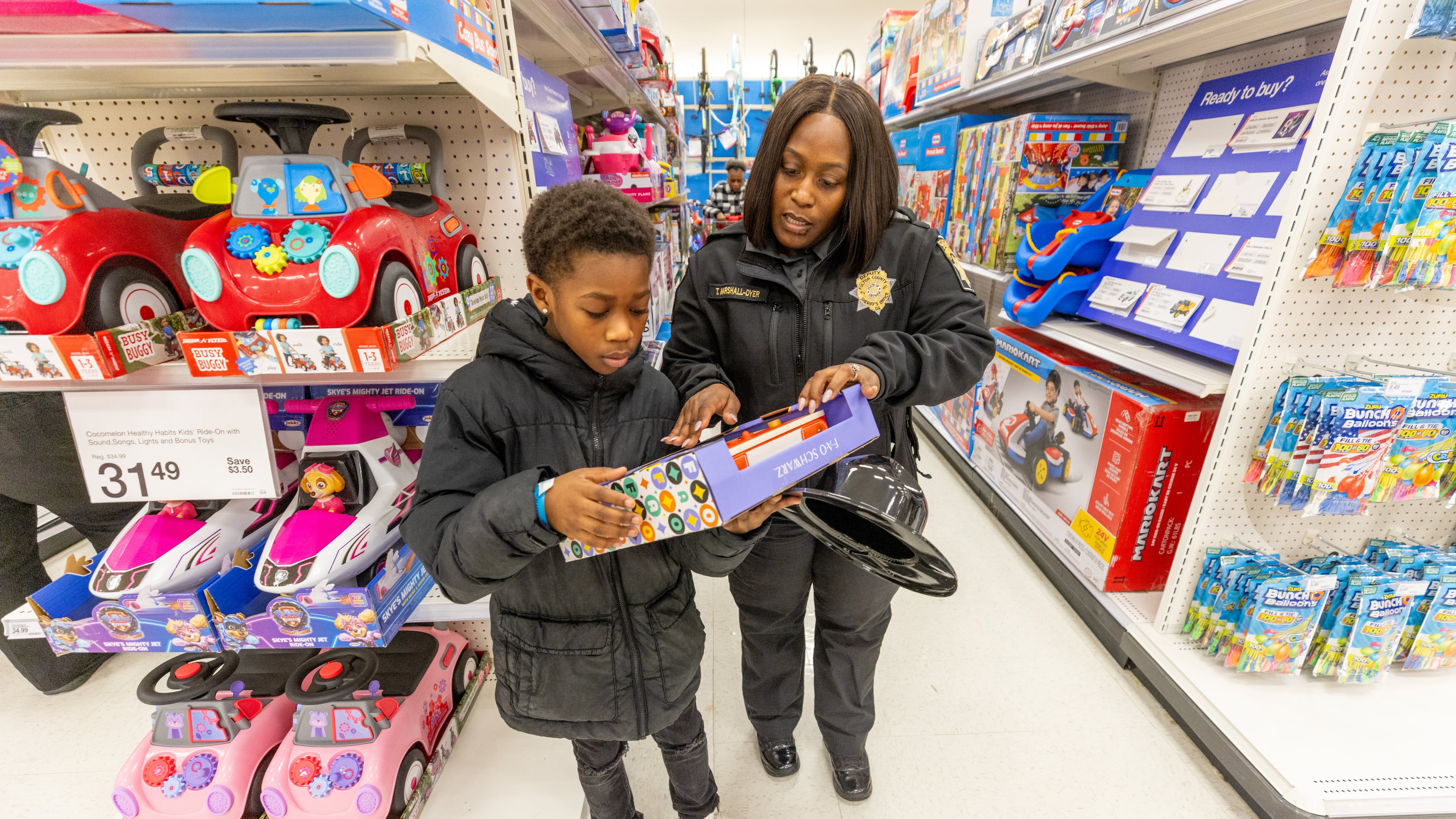 Sergeant Dreyer helps Kaleb Whidby, 9, make a decision about one of his purchases during the Shop With The Sheriff event at the Target at Atlantic Station Saturday, Dec. 9, 2023. (Steve Schaefer/steve.schaefer@ajc.com)
