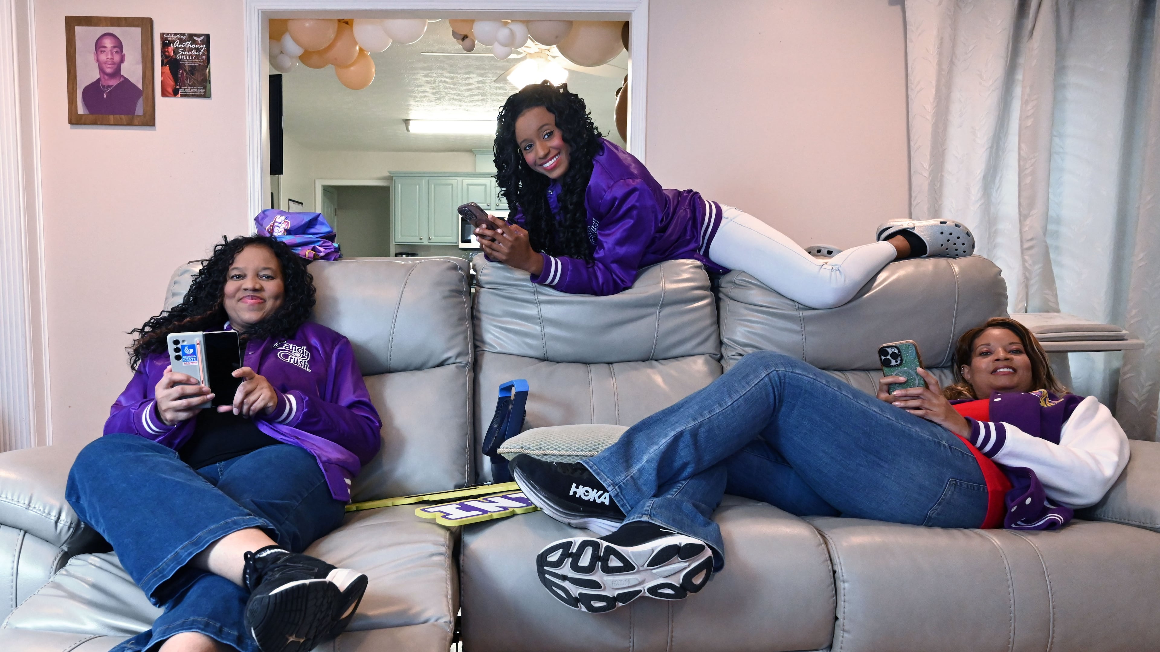 Selita Boyd, left, her sister Aalja Boyd, right, and her niece Jemini Powell, center, pose as they do when playing Candy Crush on Tuesday, Aug. 4, 2026, in Stone Mountain. All three have competed in a $1 million Candy Crush tournament, where the top 10 players compete. (Hyosub Shin/AJC)