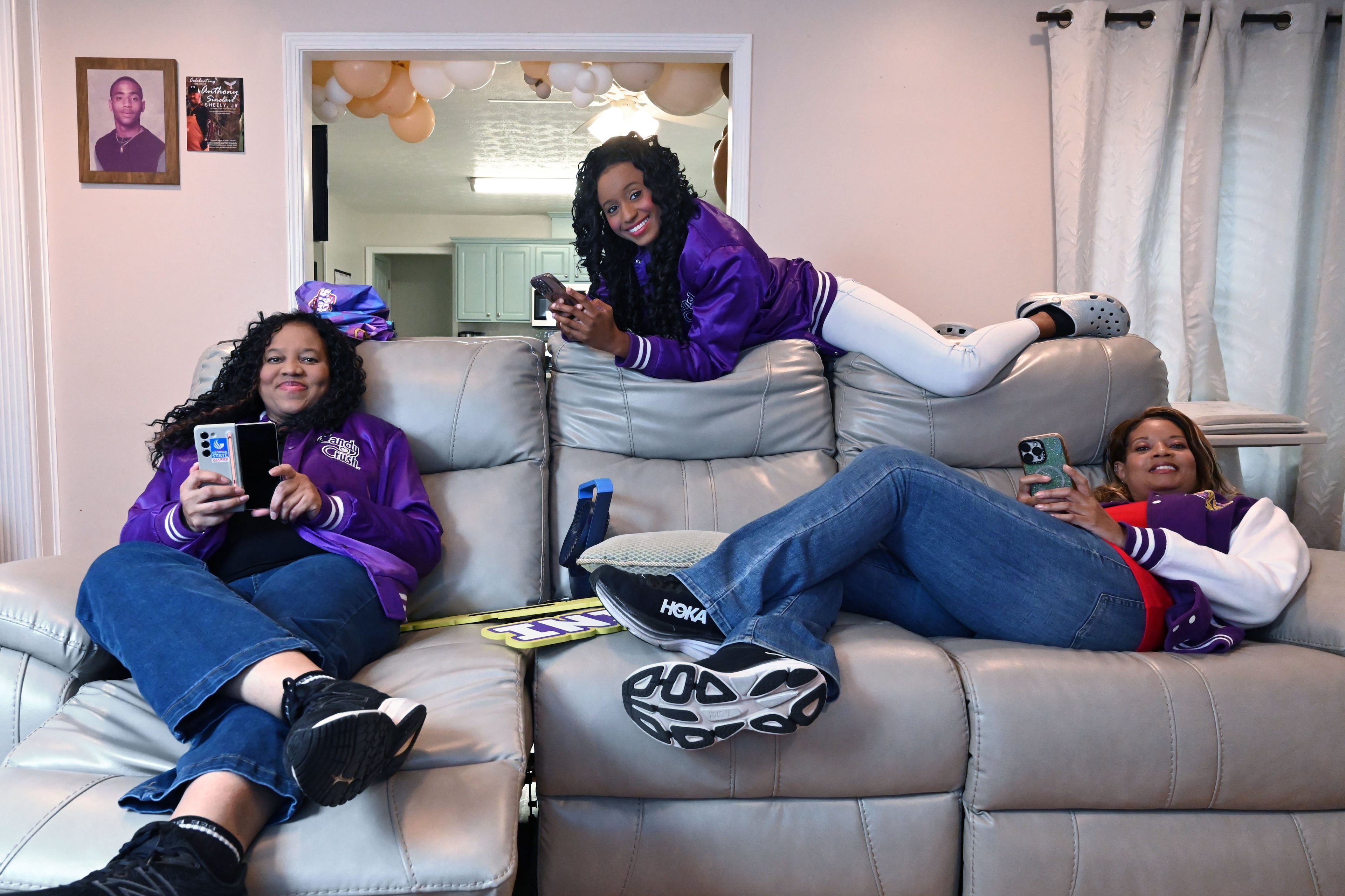 Selita Boyd, left, her sister Aalja Boyd, right, and her niece Jemini Powell, center, pose as they do when playing Candy Crush on Tuesday, Aug. 4, 2026, in Stone Mountain. All three have competed in a $1 million Candy Crush tournament, where the top 10 players compete. (Hyosub Shin/AJC)