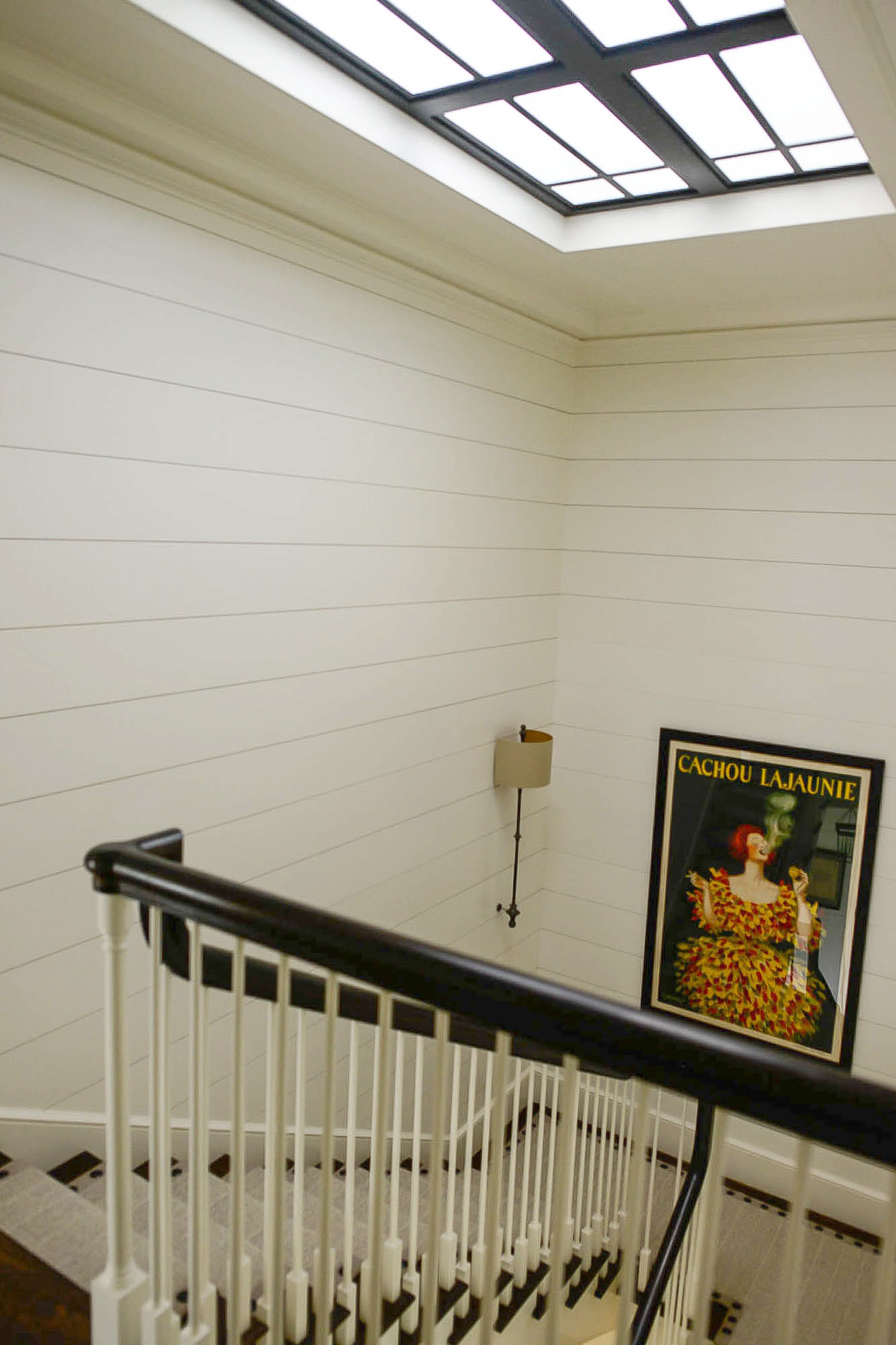 The iron skylight in the stairwell is an architectural feature found elsewhere in the home, such as the shower wall and doors from the kitchen to the covered back porch.