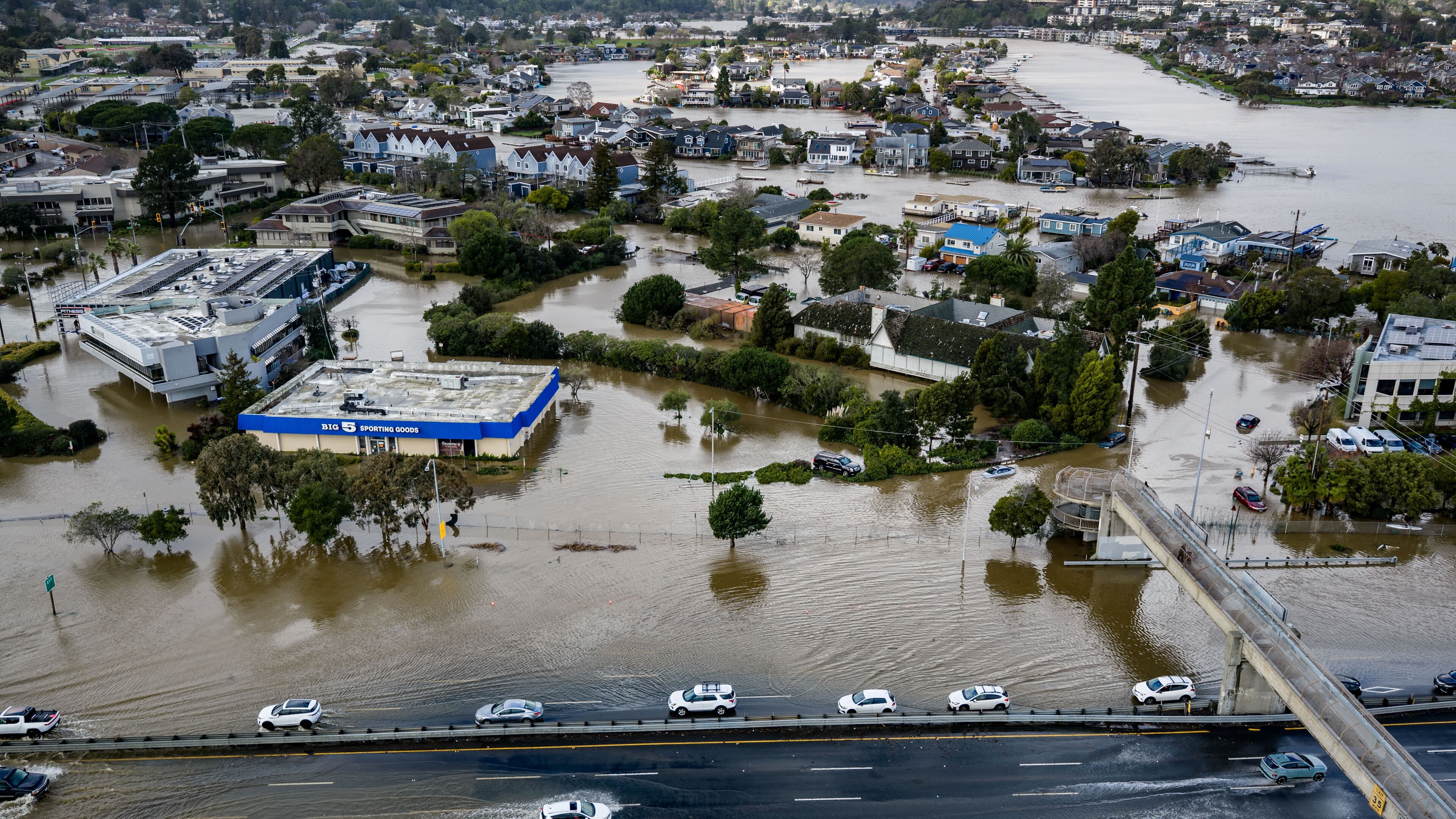 Cars drive on highway 101 flooded by the "King Tides", occurring when the sun, moon and Earth align, causing a stronger gravitational pull Saturday, Jan. 3, 2026, near Corte Madera in Marin County, Calif. (AP Photo/Ethan Swope)