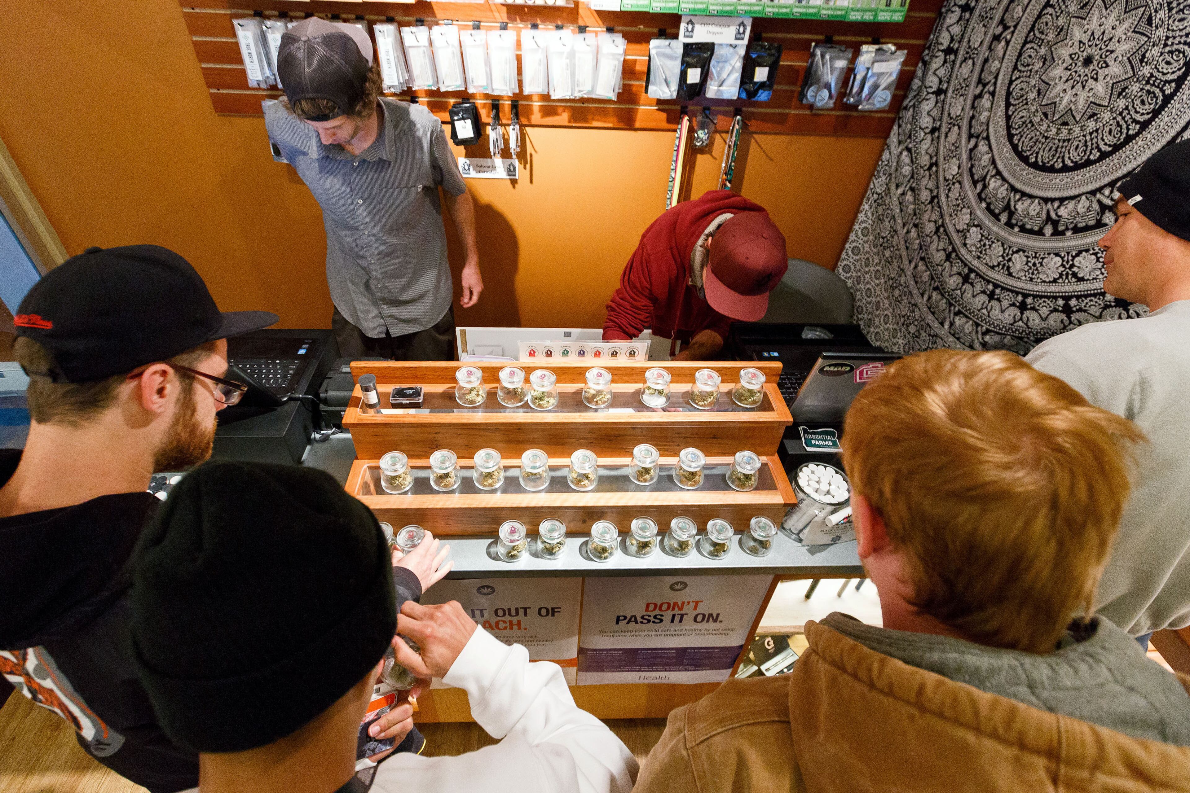 Employees of Amazon Organics, a pot dispensary in Eugene, Ore., help customers purchase recreational marijuana on Thursday, Oct. 1, 2015. Oregon marijuana shops began selling marijuana Thursday for the first time to recreational users who are at least 21 years old, marking a big day for the budding pot industry. (AP Photo/Ryan Kang)