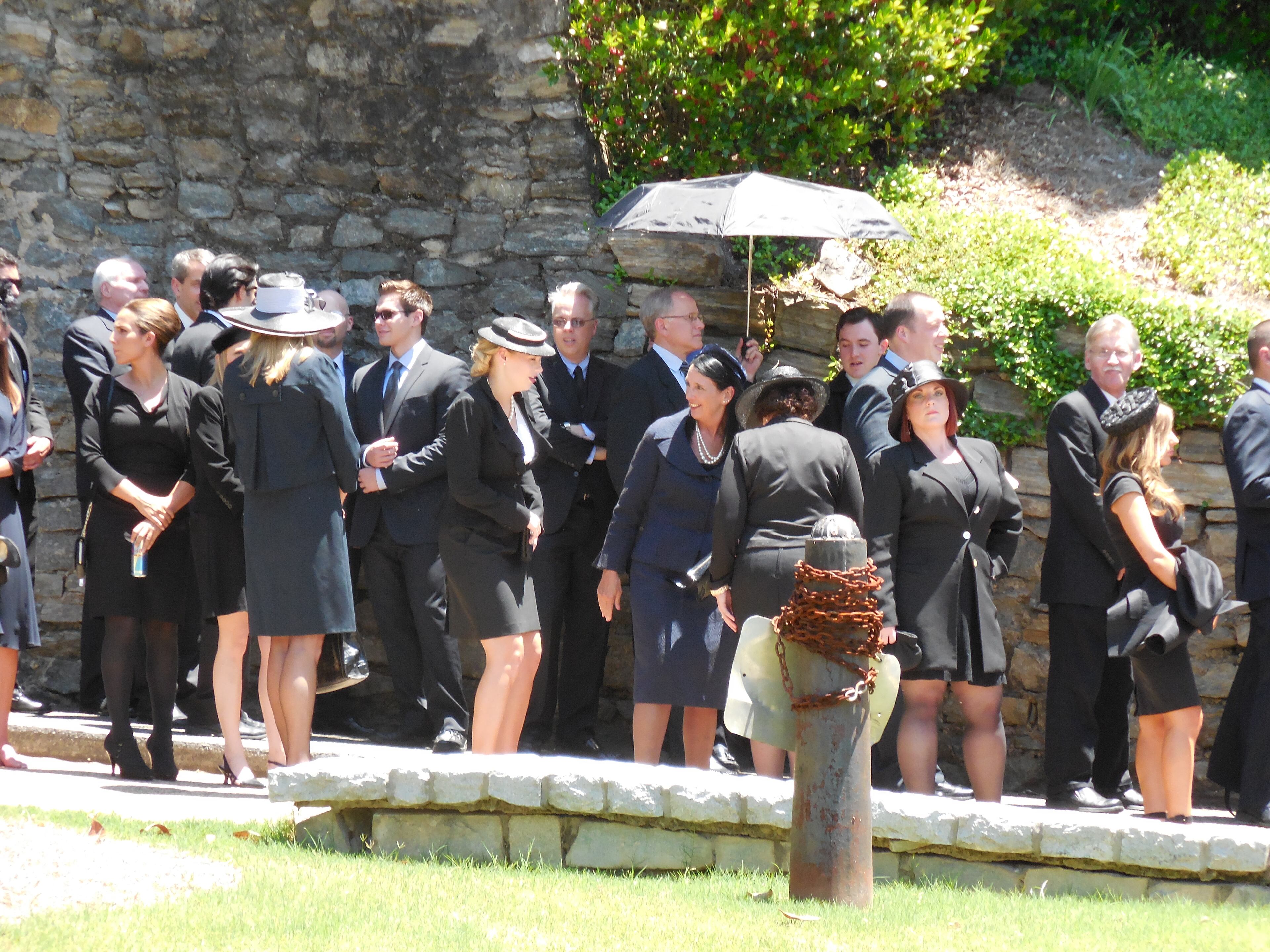 A funeral scene for "Captain America: Civil War" filmed at Peachtree Christian Church the other day. Dark clothing and a sunny day made things a little warm for the extras. Looks like someone thought ahead and brought an umbrella for some shade. Photo: Jennifer Brett