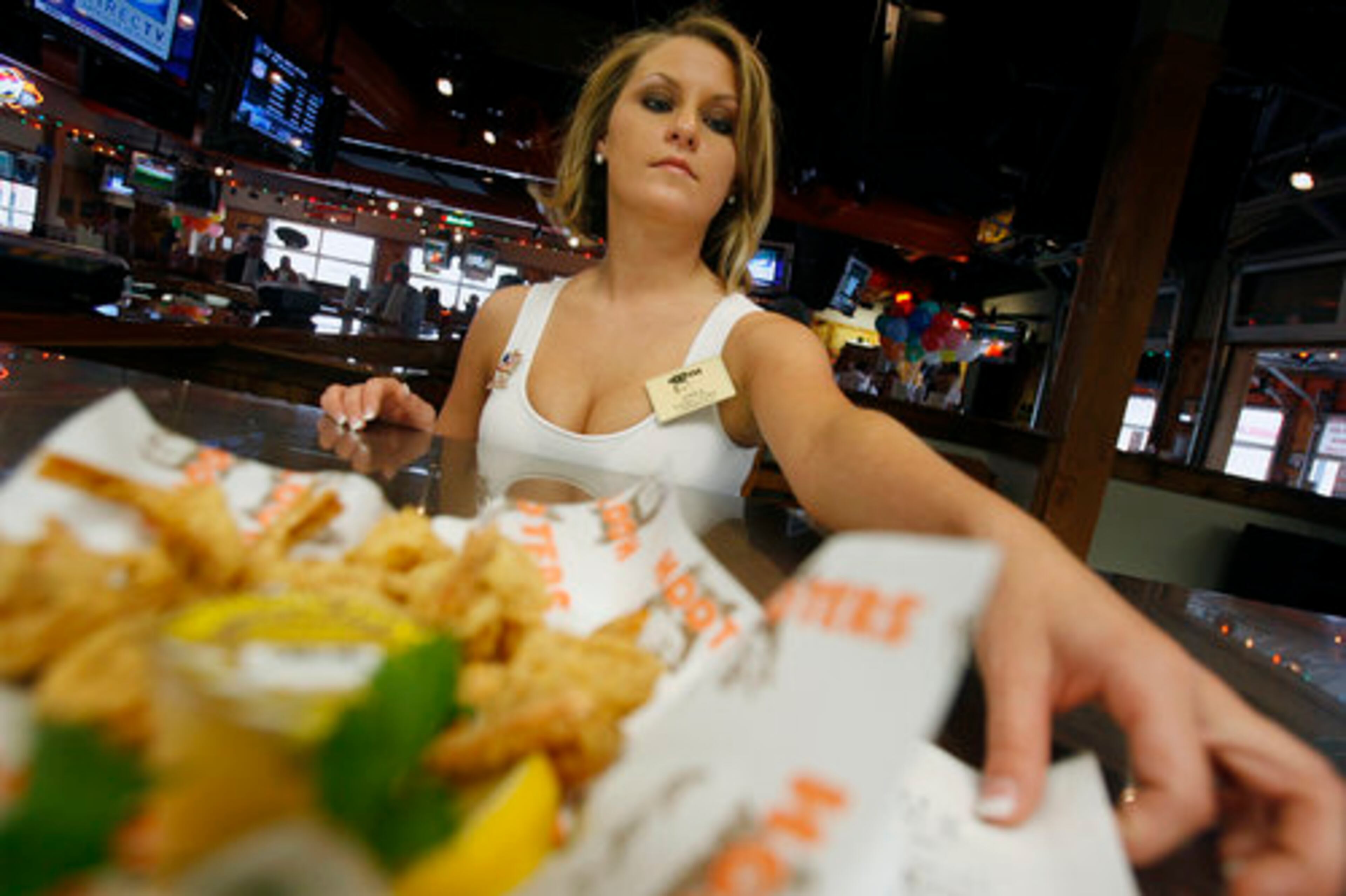 Server Anna Kummer takes an order of Buffalo Shrimp to a table during lunch hour at Hooters' Lawrenceville location.