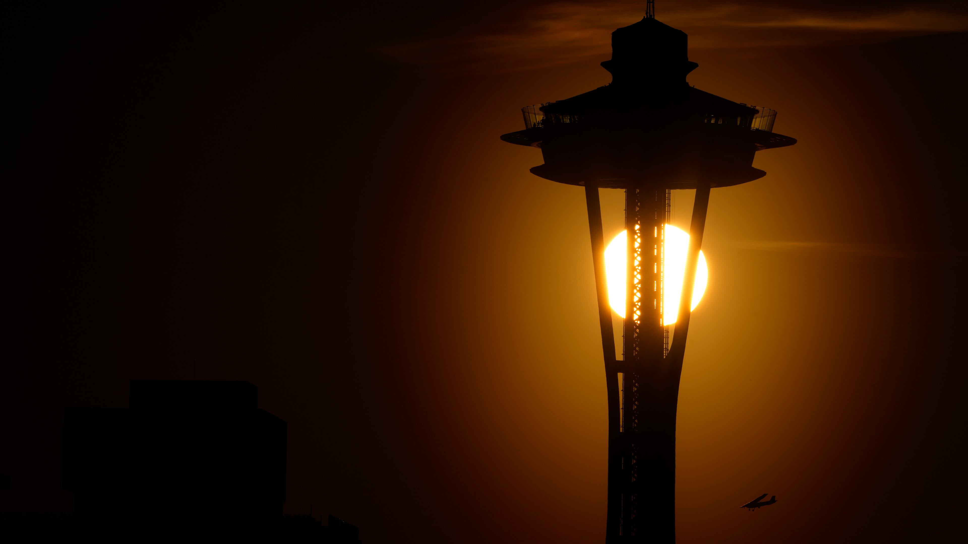 FILE - The sun sets behind the Space Needle as a small plane flies by on the first day of spring, Tuesday, March 19, 2024, in Seattle. (AP Photo/Lindsey Wasson,File)