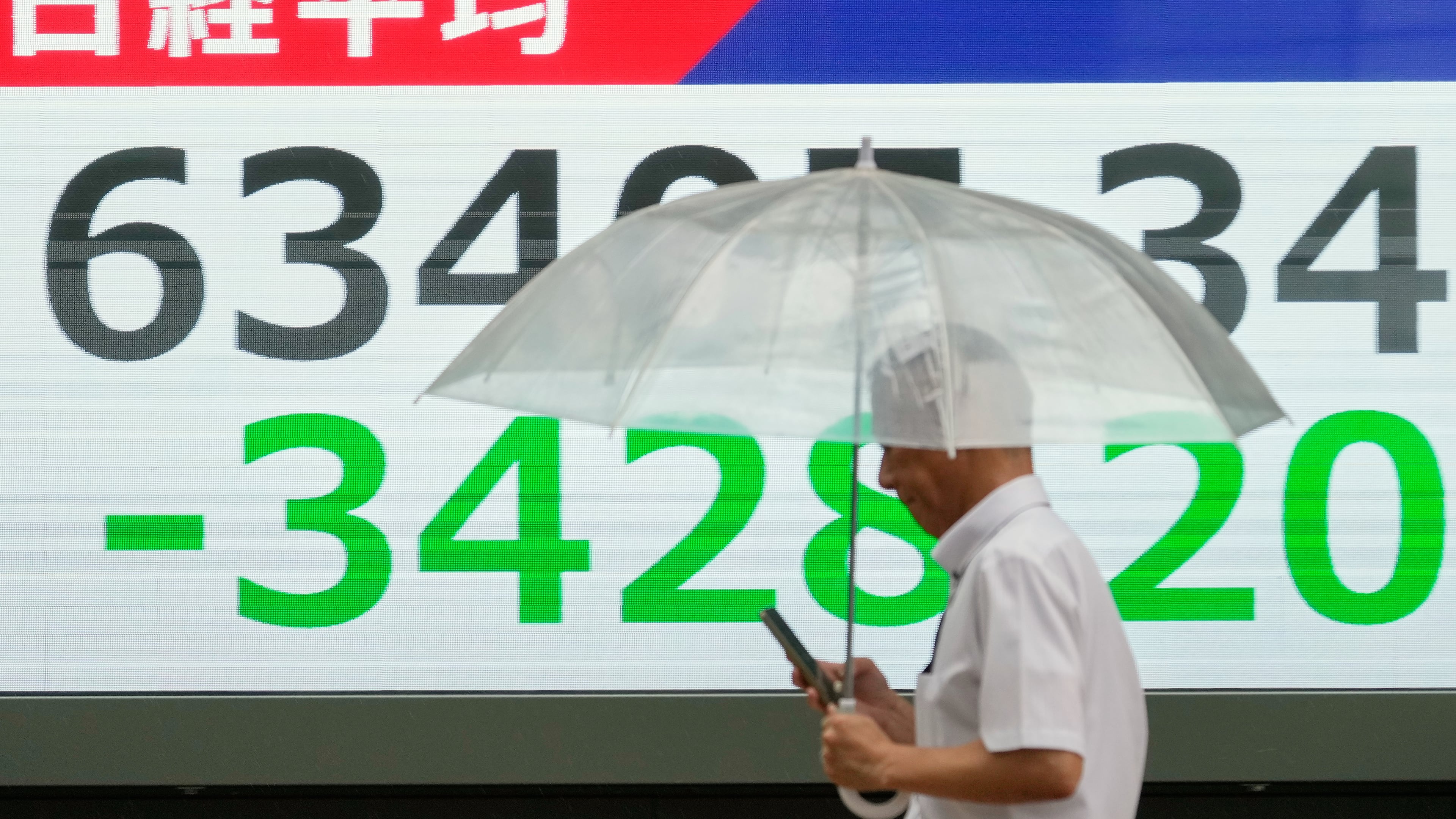 A person walks in front of an electronic stock board showing Japan's Nikkei index at a securities firm Friday, July 17, 2026, in Tokyo. (AP Photo/Eugene Hoshiko)