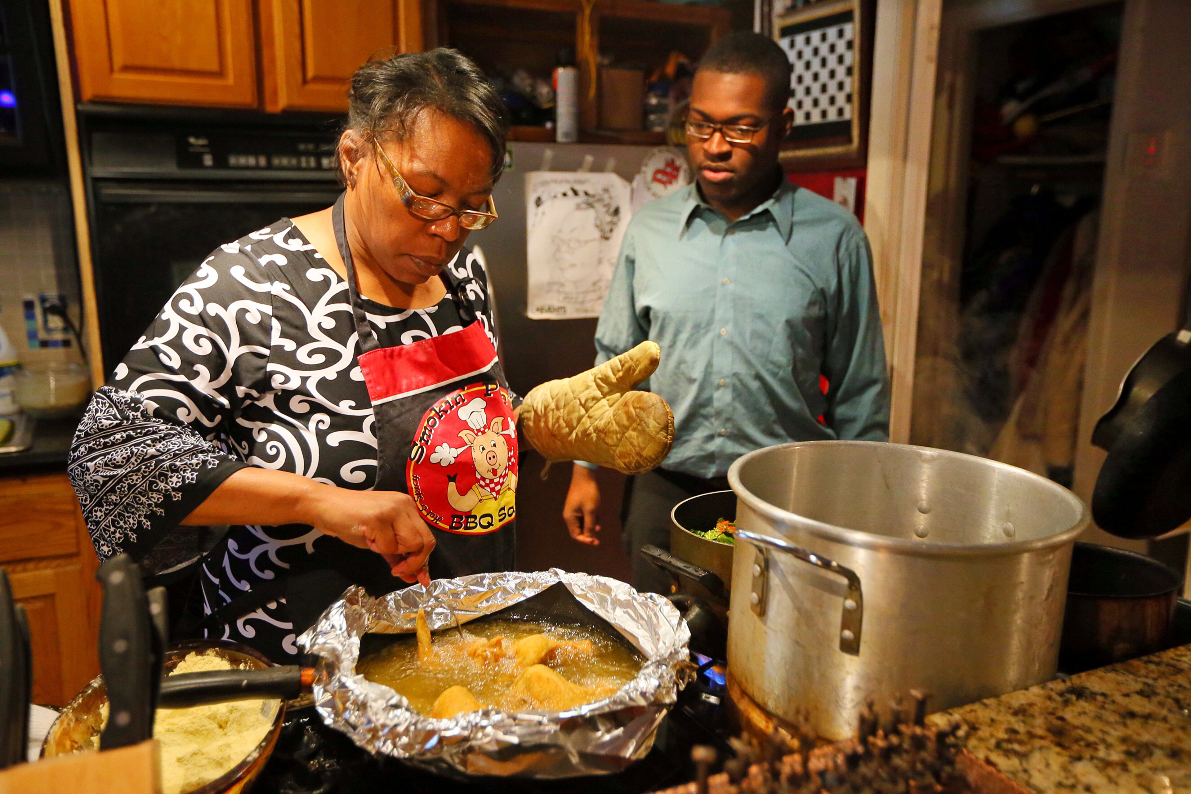 Omar's mother, Mary, cooks fried chicken, Omar's favorite dish, for Sunday dinner. His parents are teaching him to cook for himself.