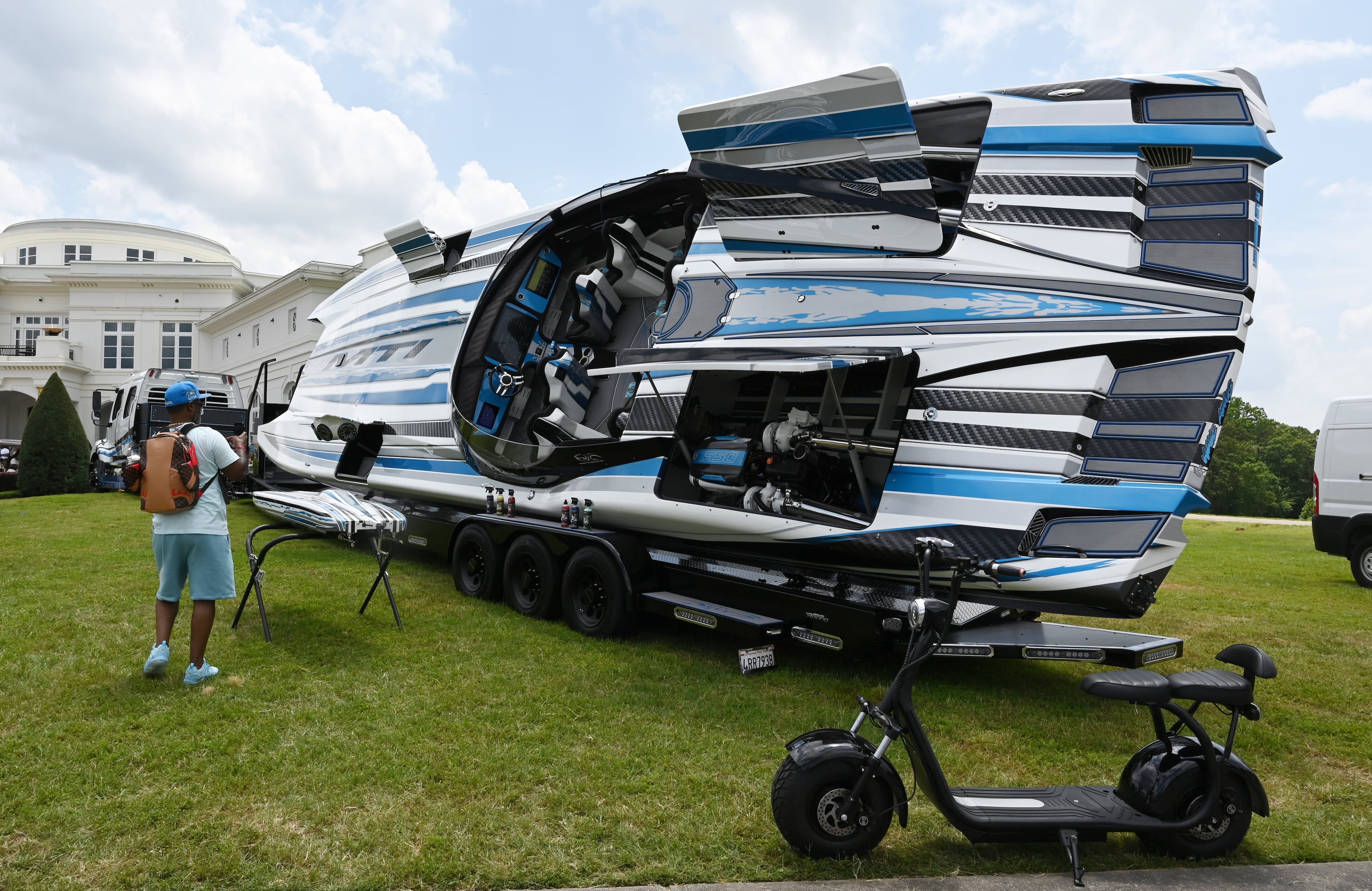 Attendees walk through fleets of classic/custom automobiles, luxury vehicles, boats, RVs and trailers on the front of the mansion during the 4th Annual Rick Ross Car and Bike Show, Saturday, June 7, 2025, in Fayetteville. The 4th Annual Rick Ross Car and Bike Show will include a vendor market with more than 30 vendors, food trucks, fleets of classic/custom automobiles, luxury vehicles, boats, RVs and trailers on the front of the mansion. Stage performances include Plies, Ross' new signee Nino Breeze and Ross himself. (Hyosub Shin / AJC)