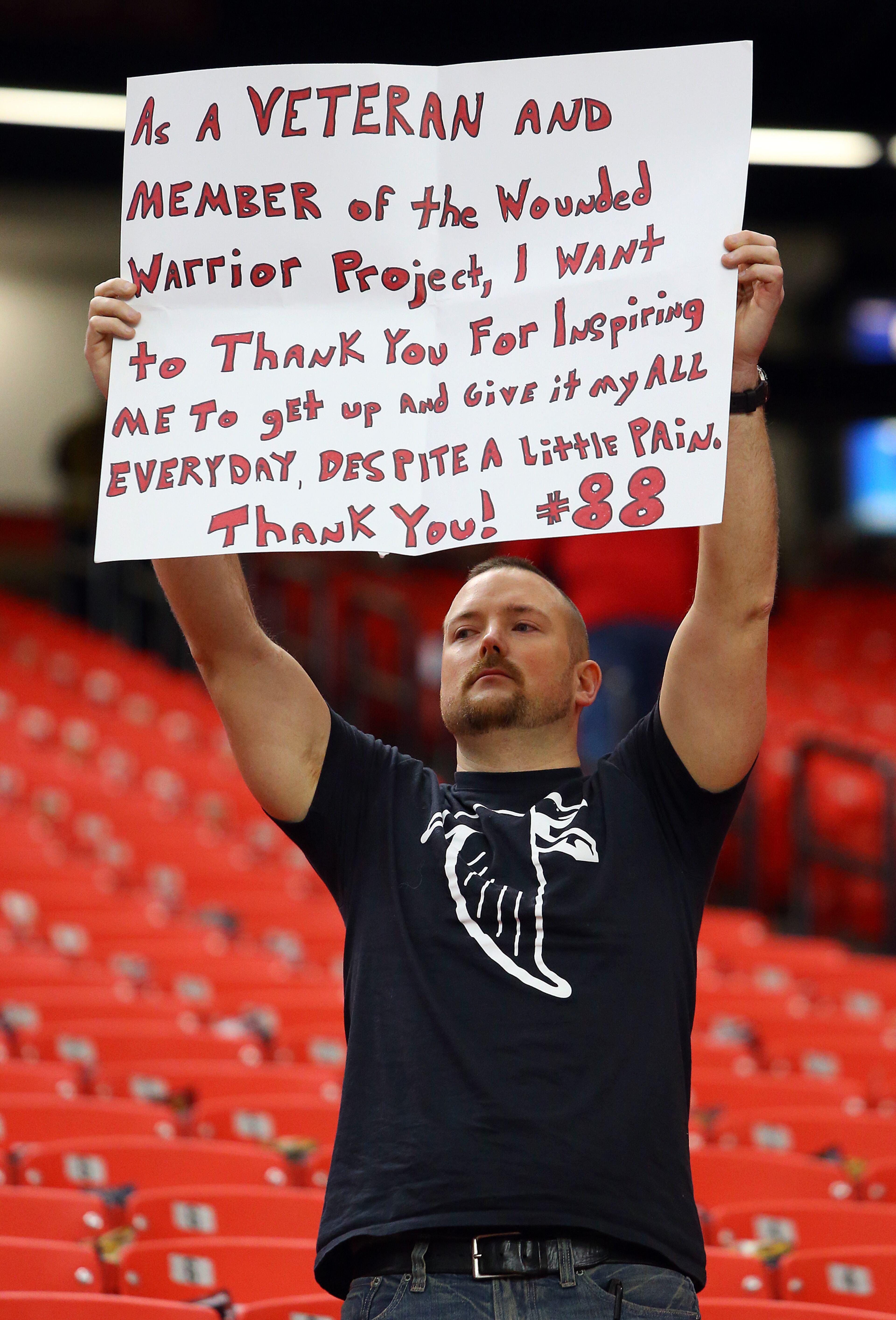 U.S. Army Iraq War veteran Paul Linkous holds a sign in support of Falcons tight end Tony Gonzalez while he prepares to play the final game of his 17-year NFL career on Sunday, Dec. 29, 2013, in Atlanta.