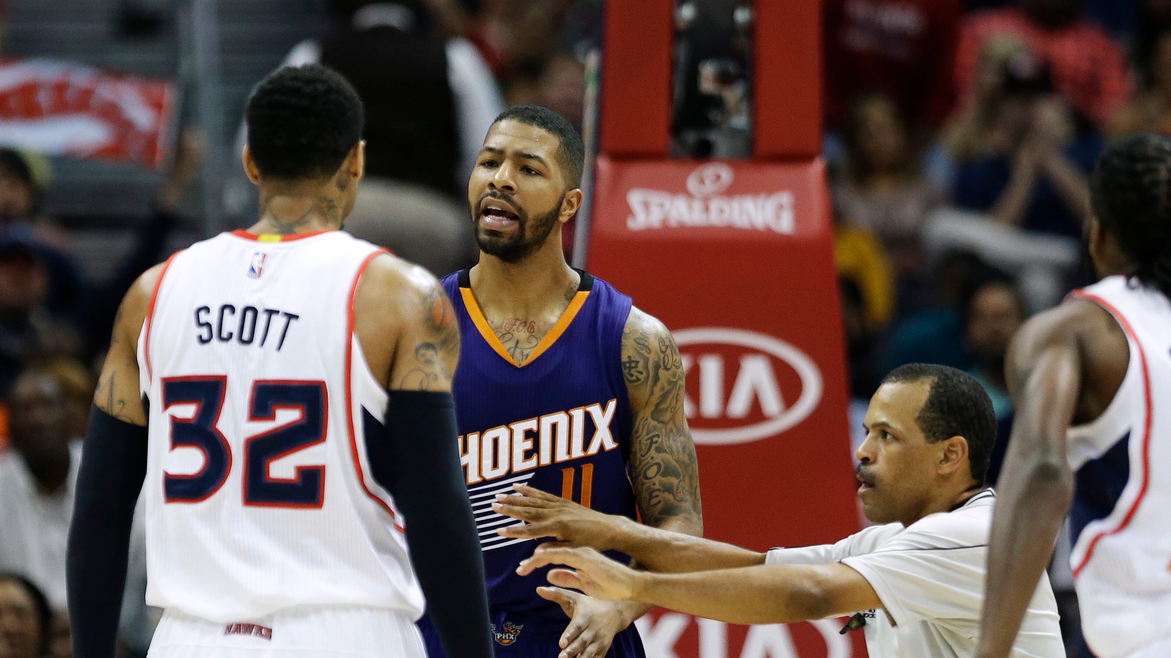 Referee Eric Lewis separates Atlanta Hawks’ Mike Scott, left, and Phoenix Suns’ Markieff Morris as they exchange words in the second quarter of an NBA basketball game Tuesday, April 7, 2015, in Atlanta. Scott was called for a technical foul on the play. (AP Photo/David Goldman)