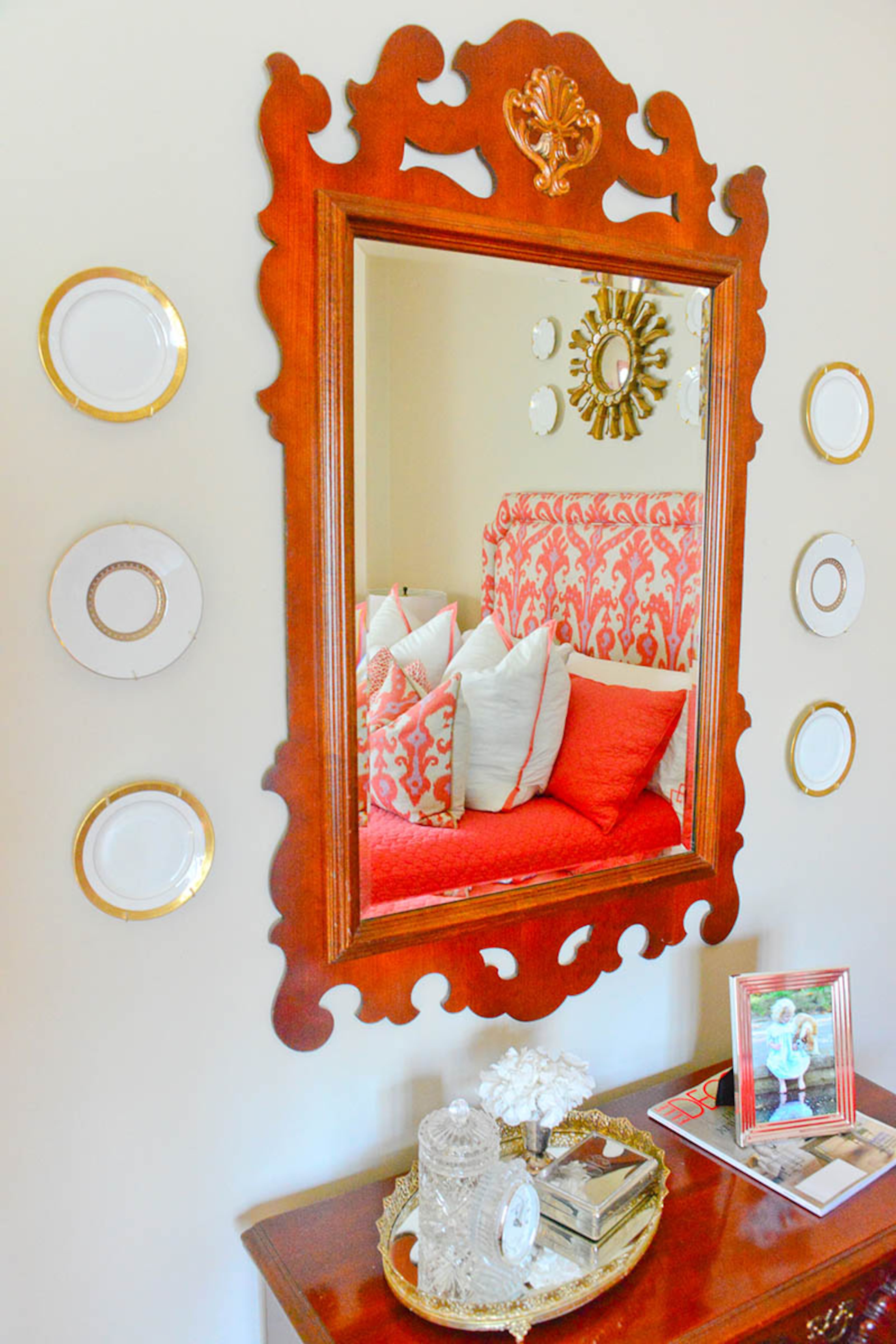 A nod to the more traditional aspects of the Luepkes' style, this display of plates and a wood-framed mirror in the upstairs guest room contrasts with the punchy colors of the bedding.