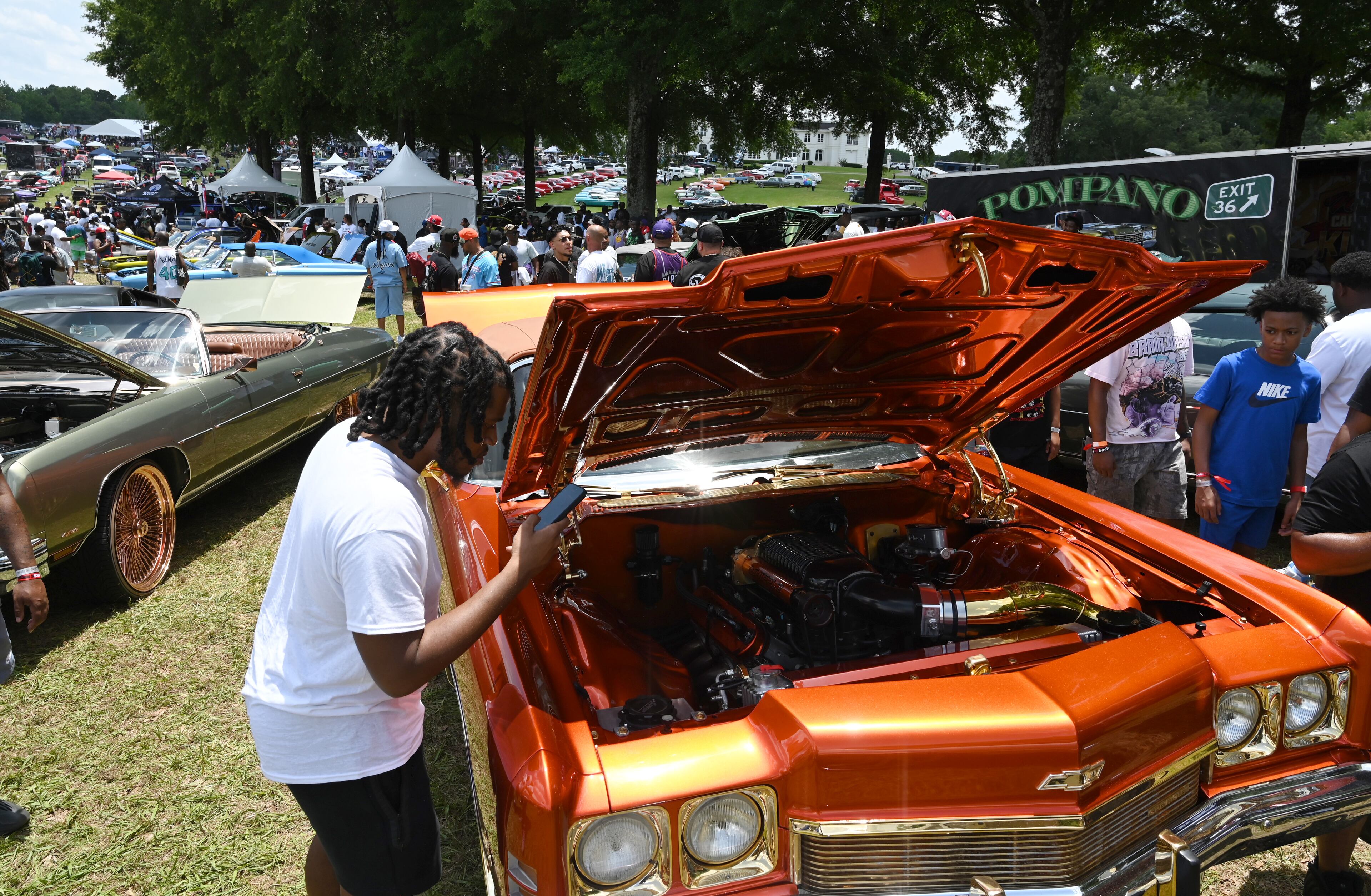 Attendees walk through some of classic/custom and luxury vehicles on Rick Ross’s property during the 4th Annual Rick Ross Car and Bike Show, Saturday, June 7, 2025, in Fayetteville. The 4th Annual Rick Ross Car and Bike Show will include a vendor market with more than 30 vendors, food trucks, fleets of classic/custom automobiles, luxury vehicles, boats, RVs and trailers on the front of the mansion. Stage performances include Plies, Ross' new signee Nino Breeze and Ross himself. (Hyosub Shin / AJC)
