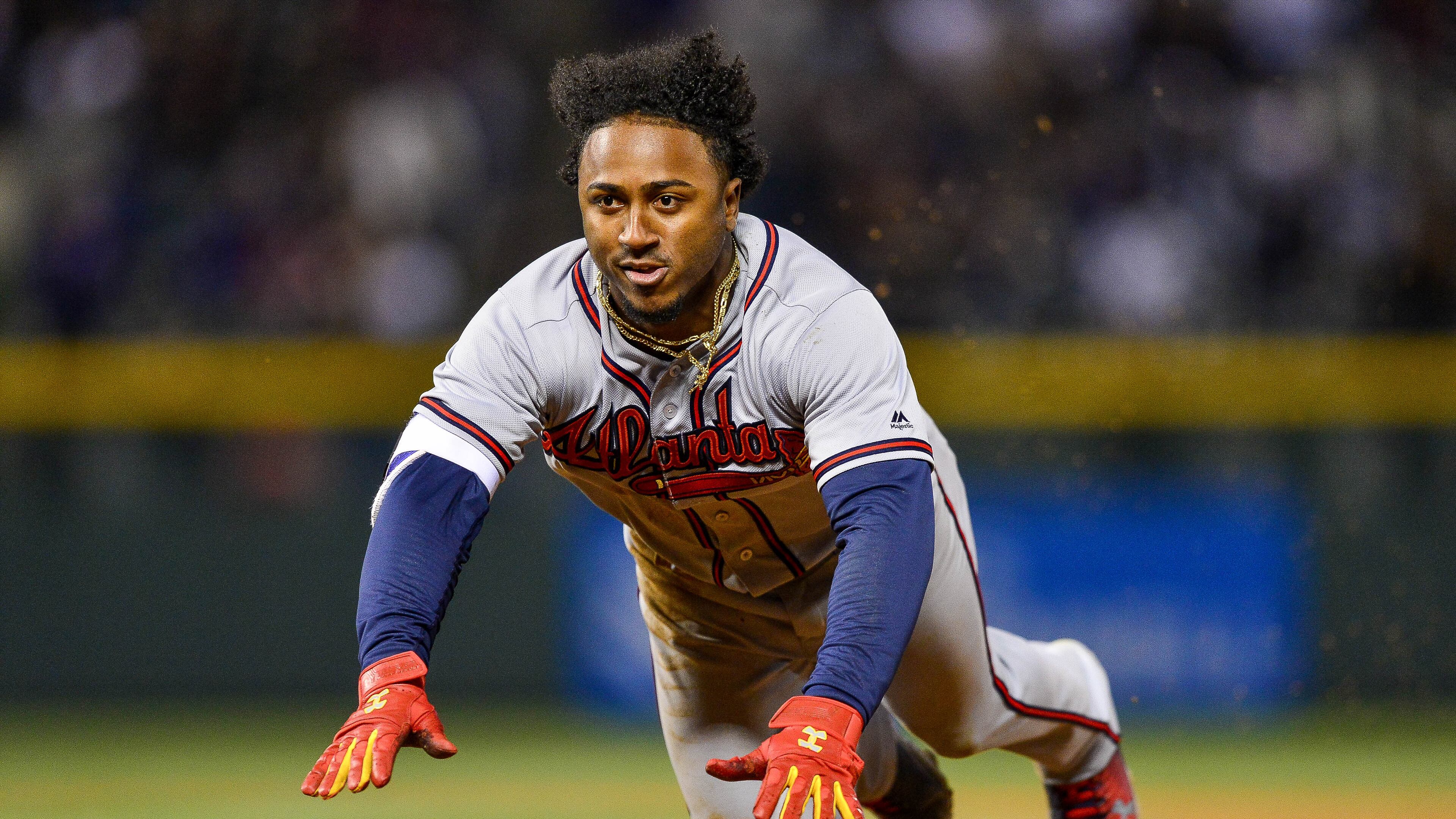Ozzie Albies dives back to first base to avoid being doubled off in the ninth inning Saturday. (Photo by Dustin Bradford/Getty Images)
