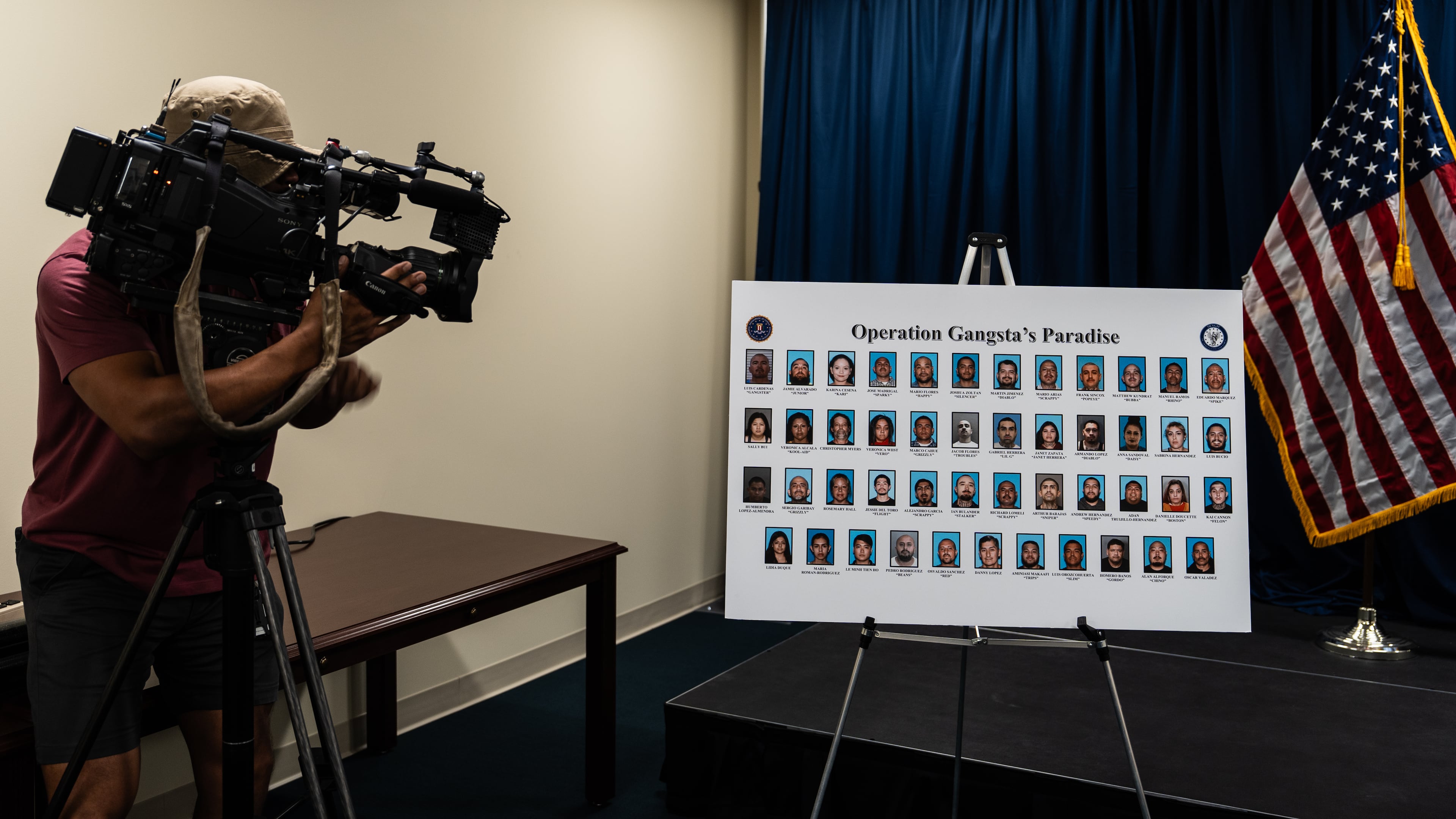 A cameraman records a board displaying individuals identified by law enforcement as members and associates of the Mexican Mafia at a news conference in Santa Ana, Calif., Thursday, April 23, 2026. (AP Photo/Jae C. Hong)