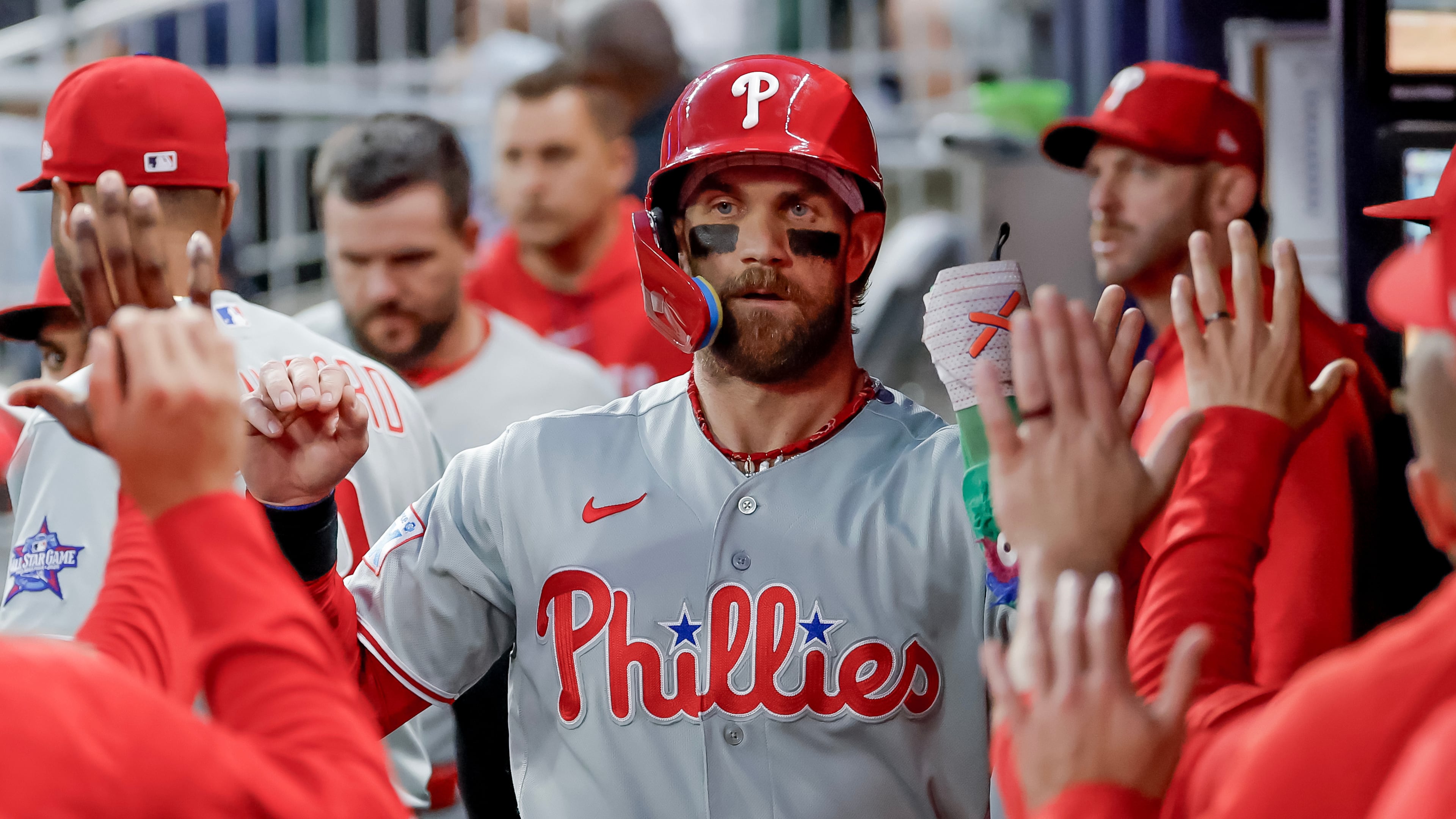 Philadelphia Phillies' Bryce Harper is greeted in the dugout after scoring against the Atlanta Braves during the first inning of a baseball game, Saturday, April 25, 2026, in Atlanta. (AP Photo/Erik S. Lesser)