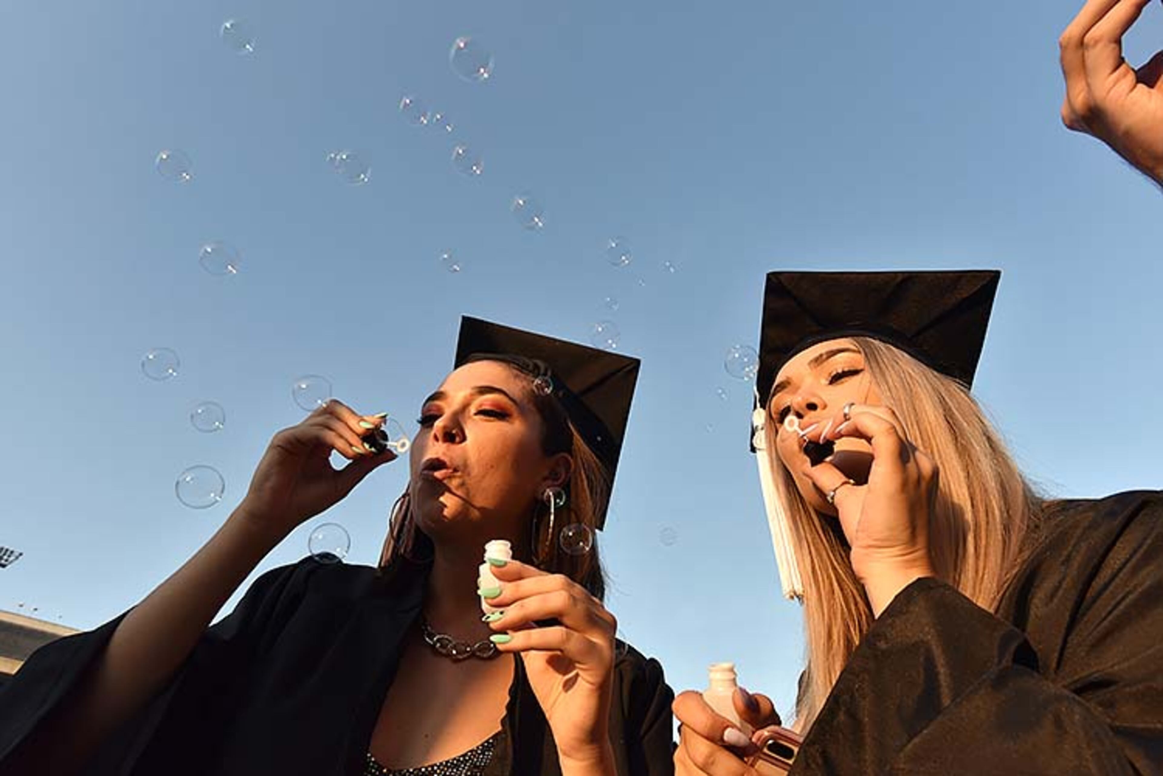 May 10, 2019 Athens - Maya Cribbs (left) and Ivey Brackett celebrate as they make bubbles before UGA's 2019 spring undergraduate commencement ceremony at Sanford Stadium in Athens on Friday, May 10, 2019. HYOSUB SHIN / HSHIN@AJC.COM