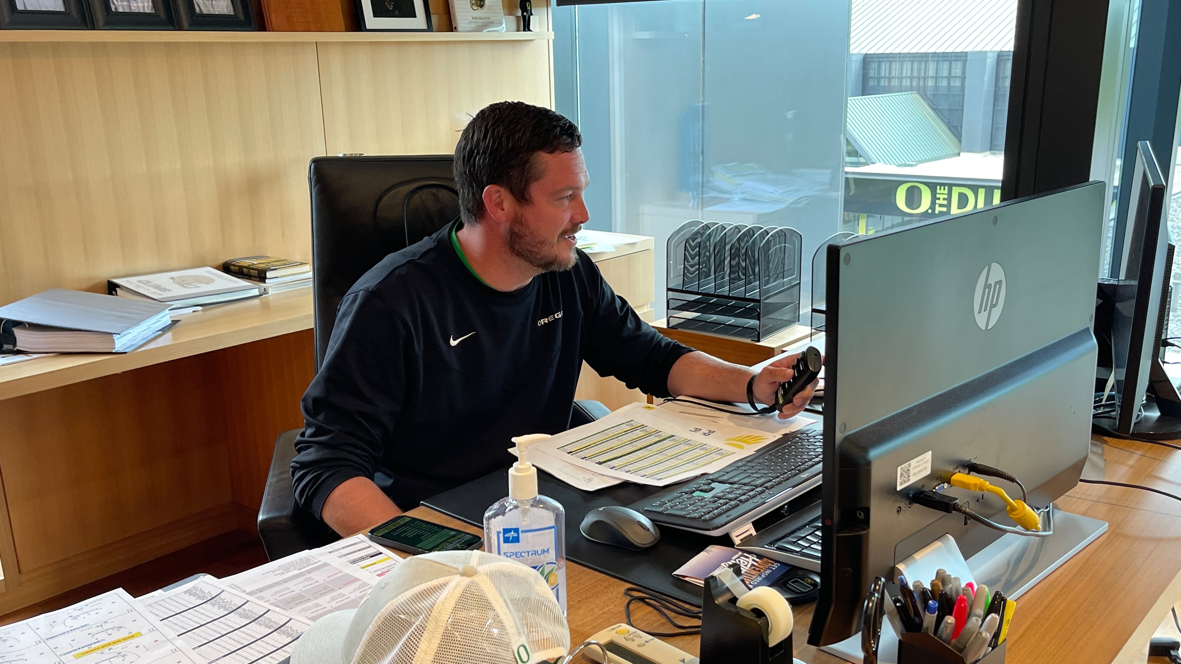 Oregon coach Dan Lanning, just seven months on the job since leaving Georgia as defensive coordinator, scrolls through some practice video in his office in the third floor of the Ducks' Hatfield-Dowlin football operations building in Eugene, Ore., on Aug. 8, 2022. (Photo by Chip Towers/ctowers@ajc.com)