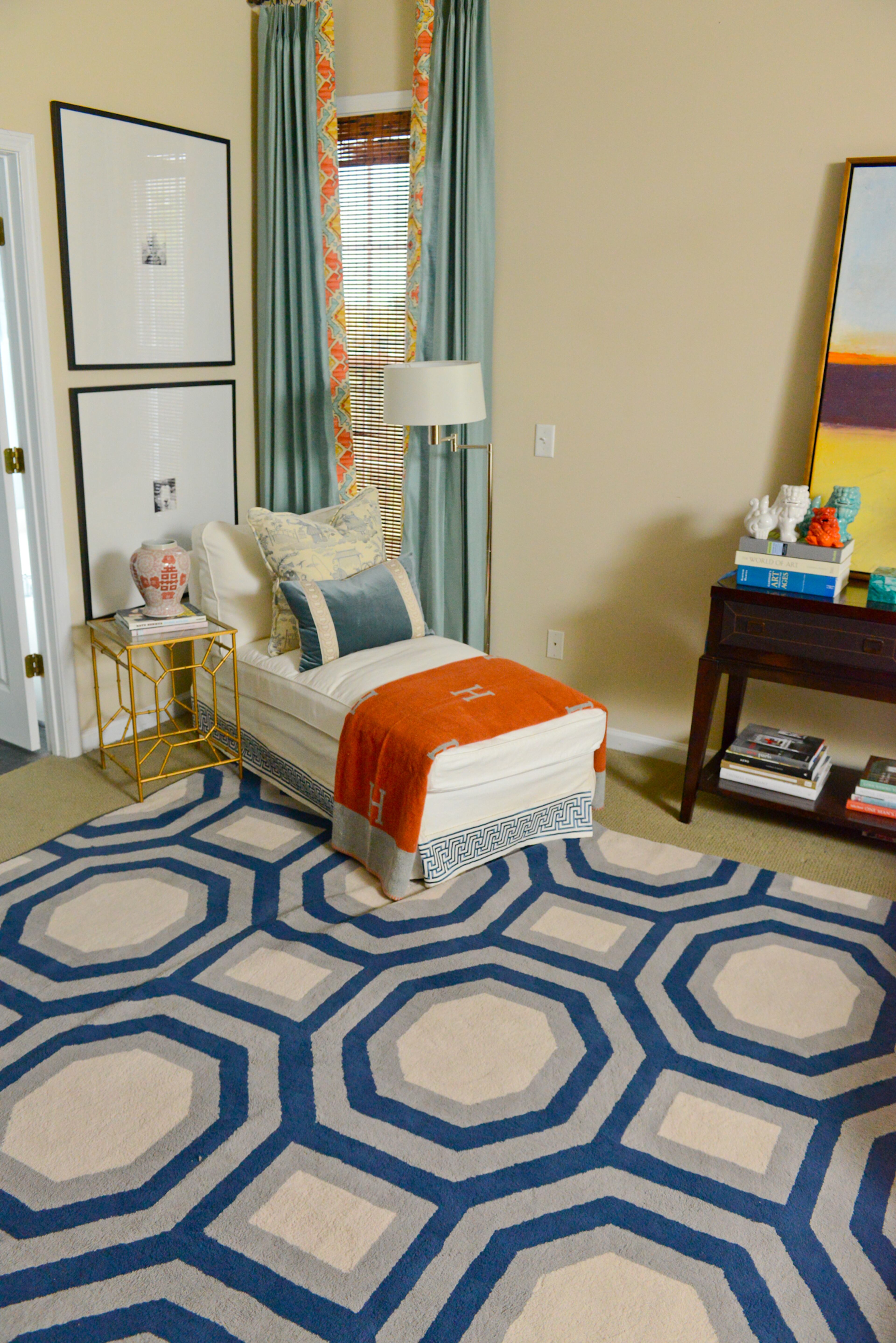 In the master bedroom, splashes of coral can be found in the drapery, the throw on the chaise, ginger jar accessories and even the artwork from Etsy. The chaise, from Ikea, has a Schumacher custom trim.