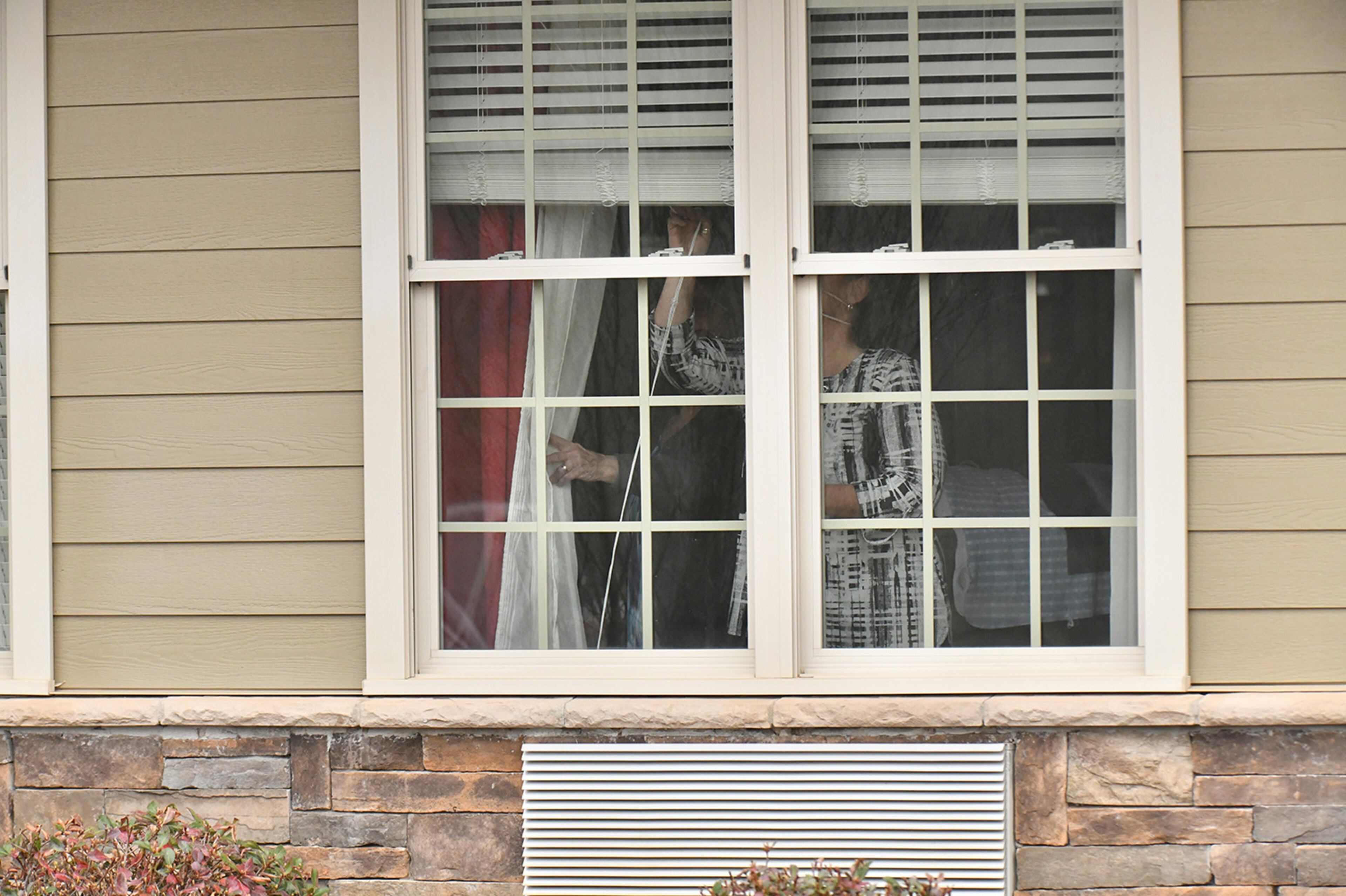 Senior living facility staff close a window at The Retreat at Canton, where confirmed that three residents and an employee have tested “presumptively positive” for COVID-19, on Tuesday, March 17, 2020. A second senior care facility, PruittHealth — Grandview, on Tuesday reported a positive test for the virus.(Hyosub Shin / Hyosub.Shin@ajc.com)