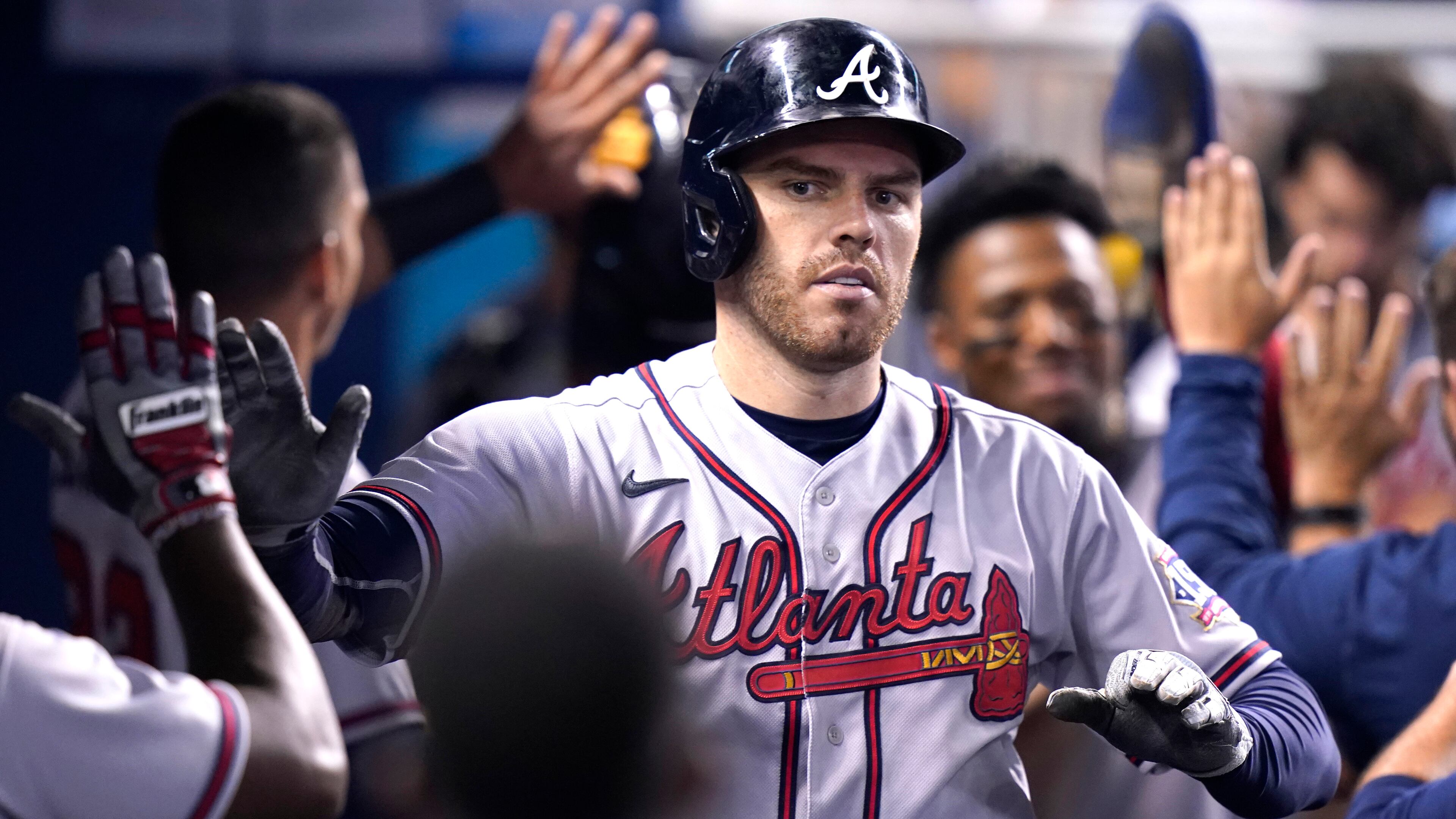 Atlanta Braves' Freddie Freeman is congratulated in the dugout after hitting a two-run home run during the fifth inning of a baseball game against the Miami Marlins, Saturday, July 10, 2021, in Miami. (AP Photo/Lynne Sladky)
