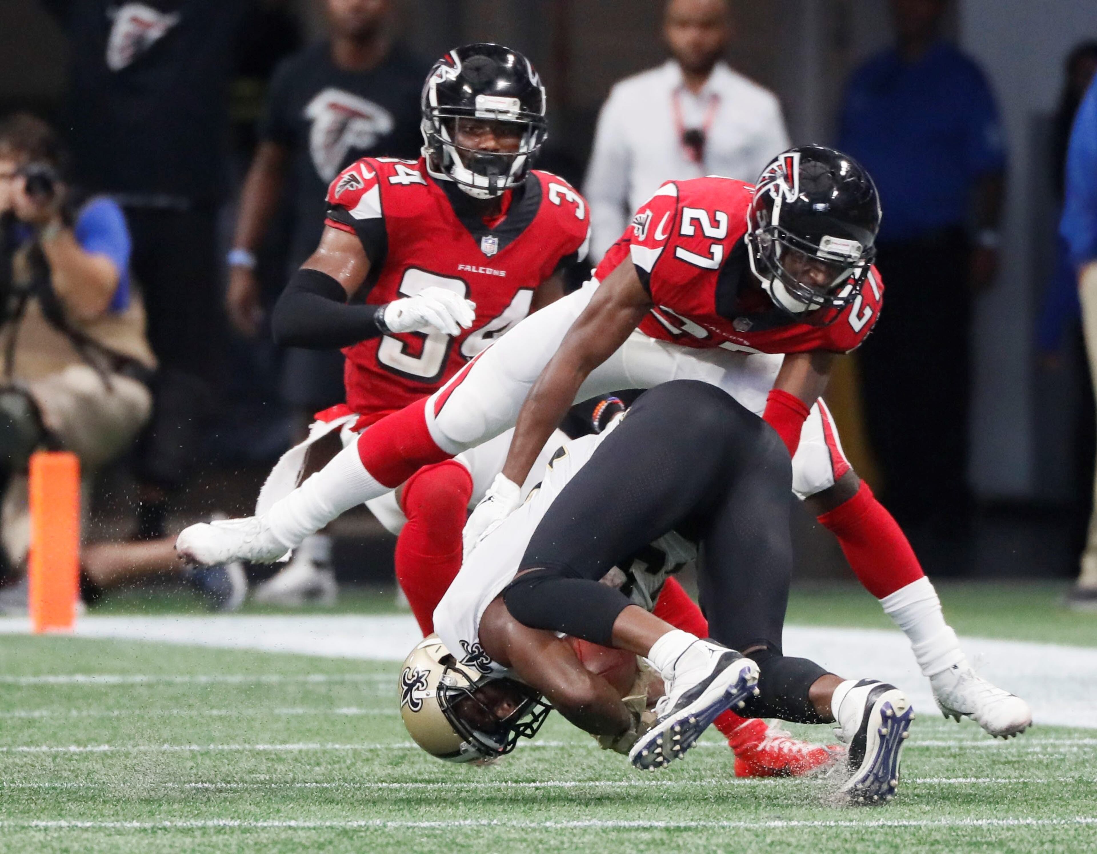 9/23/18 - Atlanta - Atlanta Falcons cornerback Damontae Kazee (27) and Atlanta Falcons cornerback Brian Poole (34) slow down New Orleans Saints wide receiver Michael Thomas (13) on the Saints tying scoring drive at the end of the second half. The Atlanta Falcons played the New Orleans Saints in an NFL football game Sunday, Sept 23, 2018, at Mercedes-Benz Stadium in Atlanta, GA. BOB ANDRES /BANDRES@AJC.COM