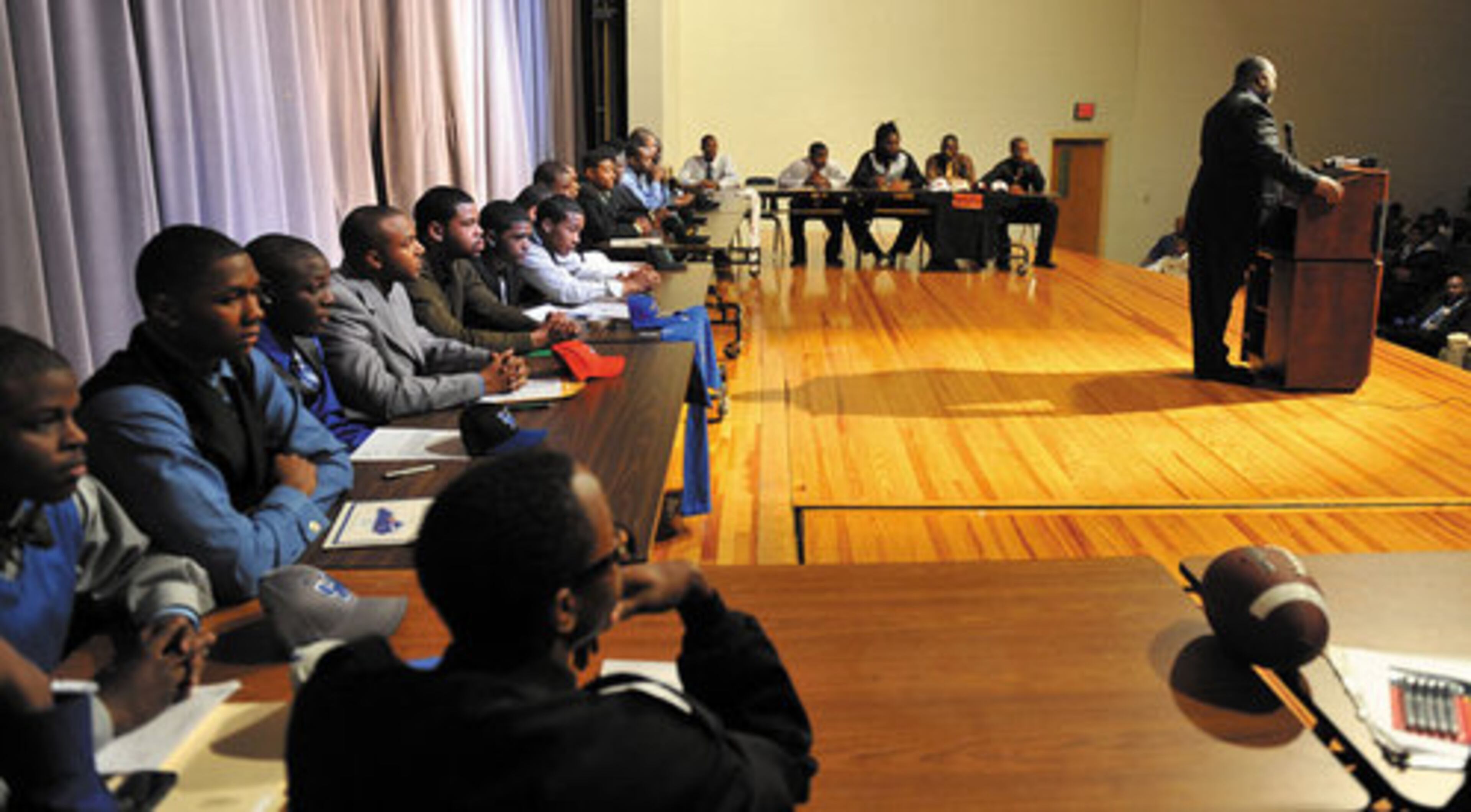 Stephenson High School head coach Ron Gartrell speaks as his players wait to announce which college they will attend. The school had 28 football players set to sign to play college football on Wednesday morning.