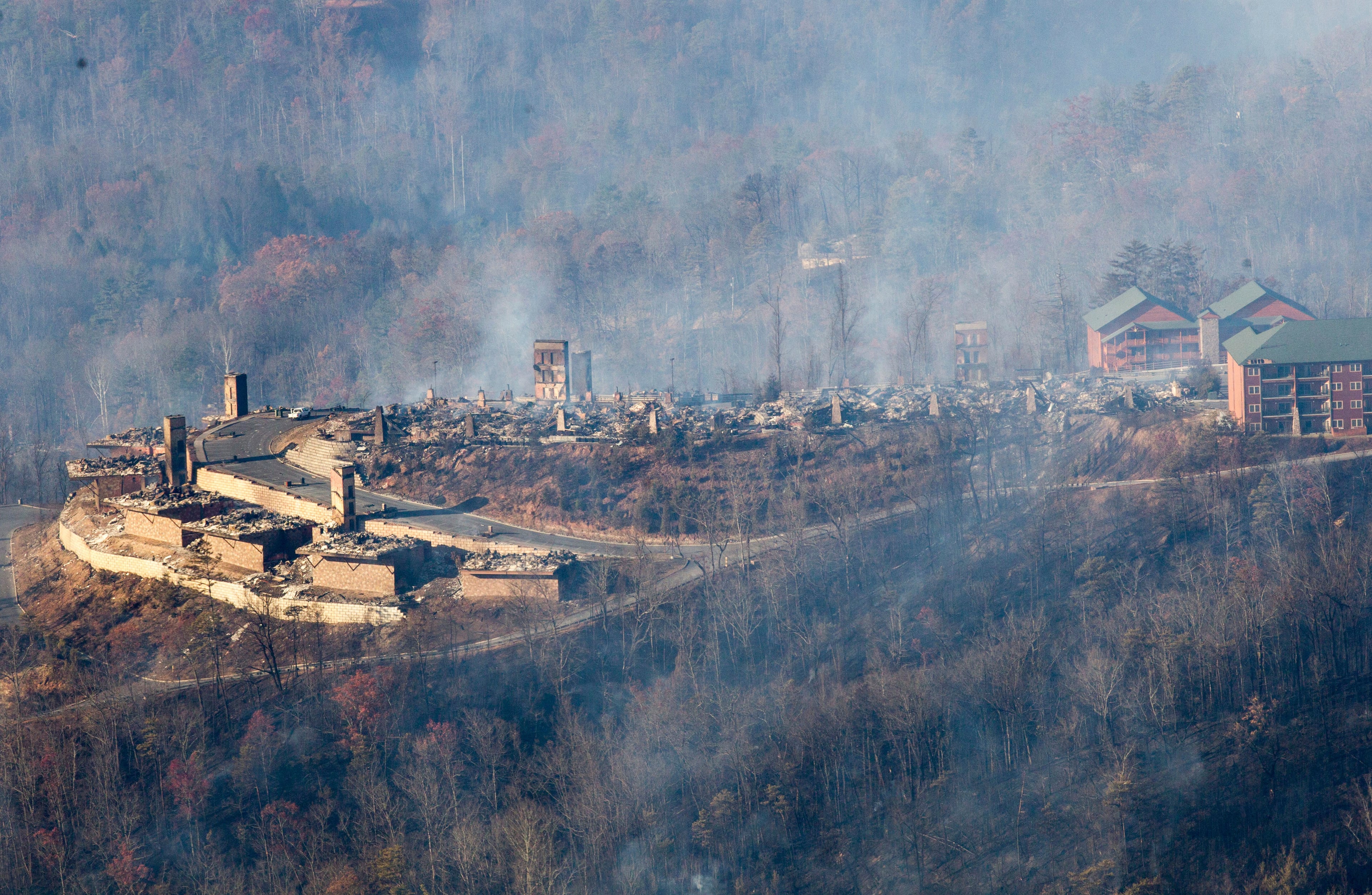 Burned structures are seen from aboard a National Guard helicopter near Gatlinburg, Tenn., Tuesday, Nov. 29, 2016. Thousands of people raced through a hell-like landscape to escape wildfires that killed several people and destroyed hundreds of homes in the Great Smoky Mountains. (AP Photo/Erik Schelzig)